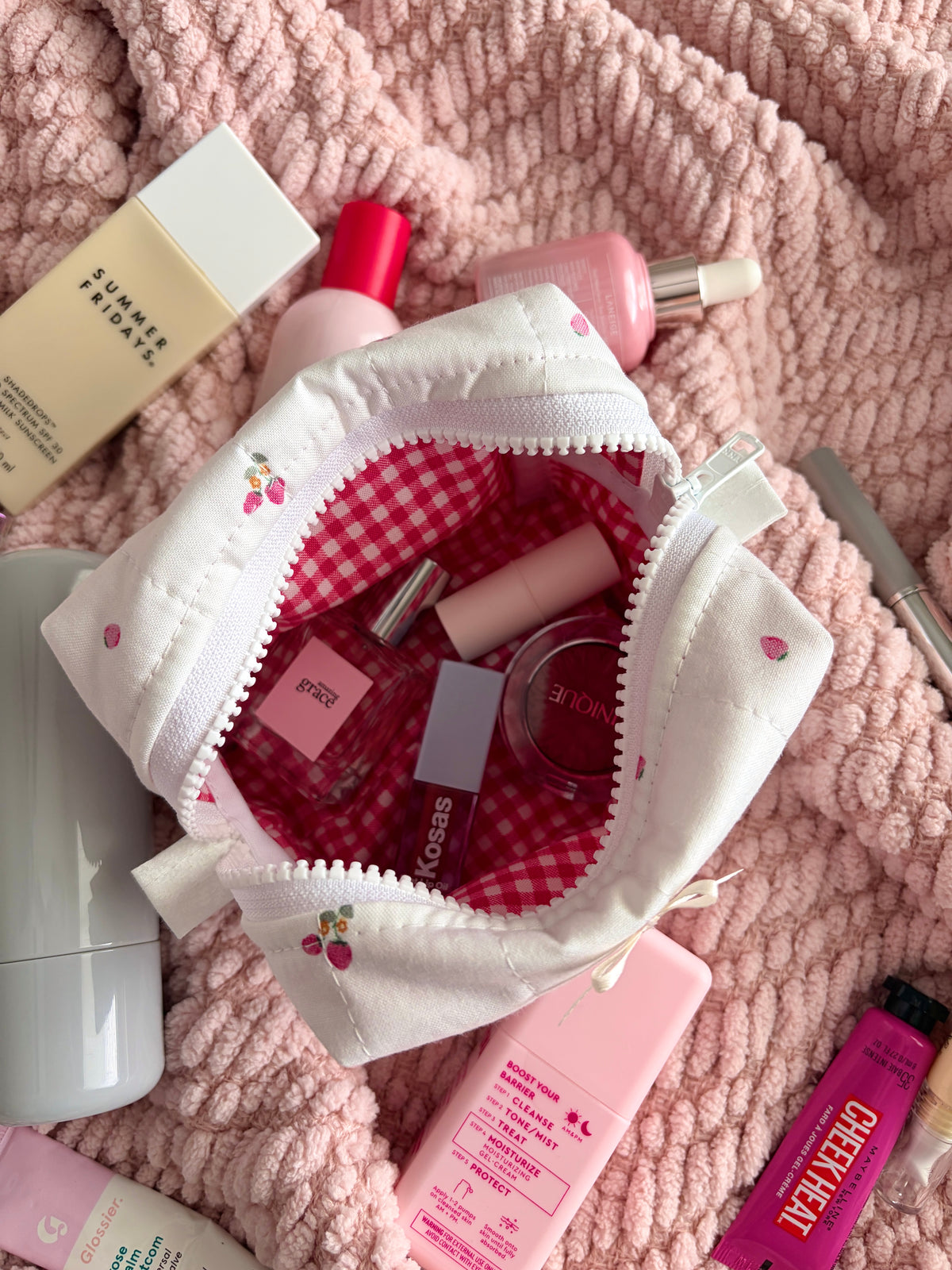 Ivory mini makeup bag open to red gingham lining with inner pockets