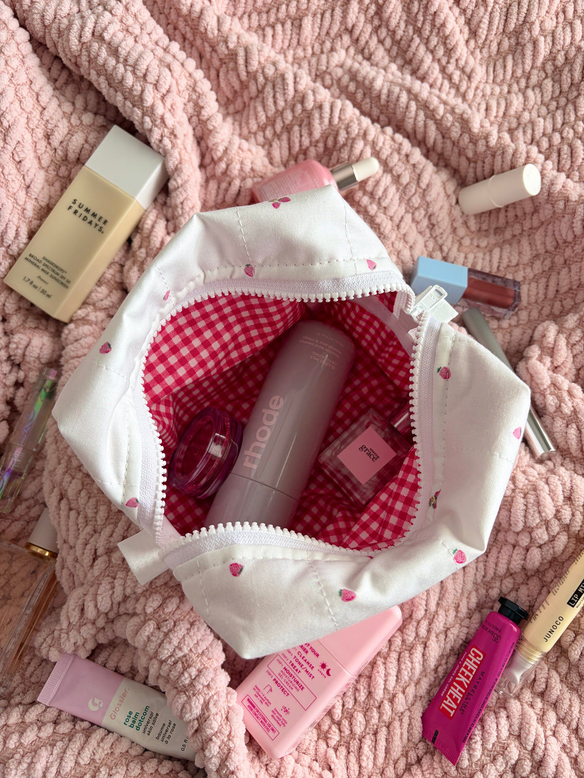 Medium cream makeup bag opened wide, showing red gingham lining inside pouch