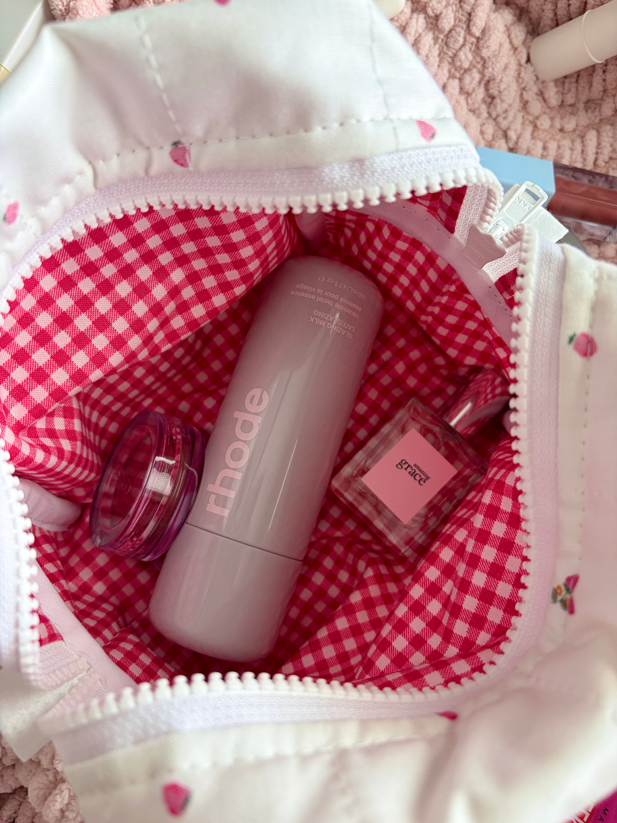 Medium cream makeup bag interior with red gingham lining and skincare bottles