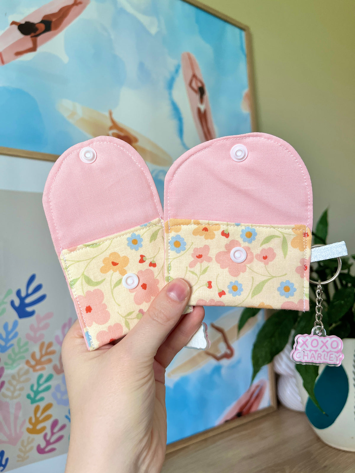 Pair of pink-and-floral earbud case pouches with clasp and keyring, held together