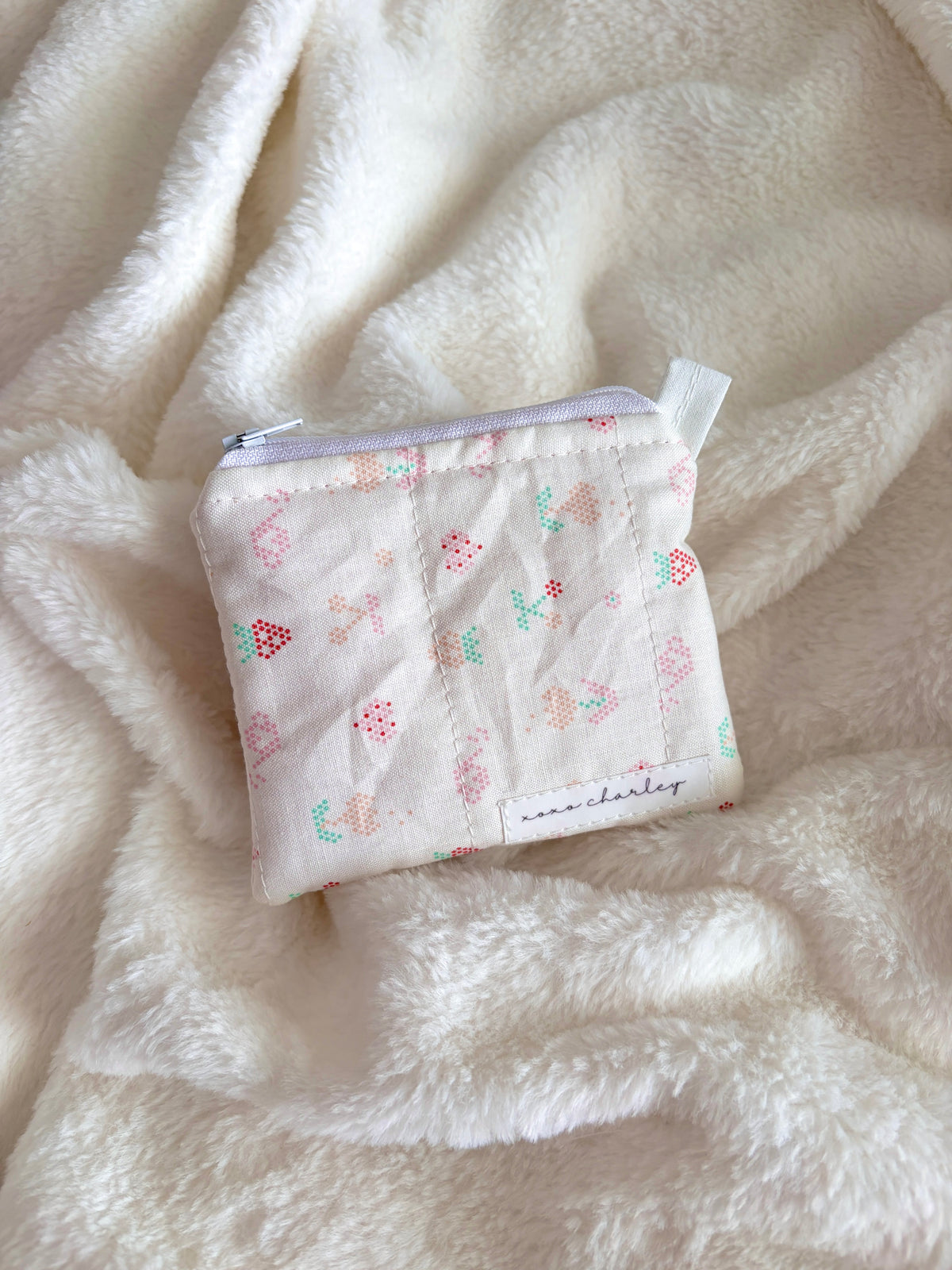 Small pouch with floral pattern on a fluffy white surface