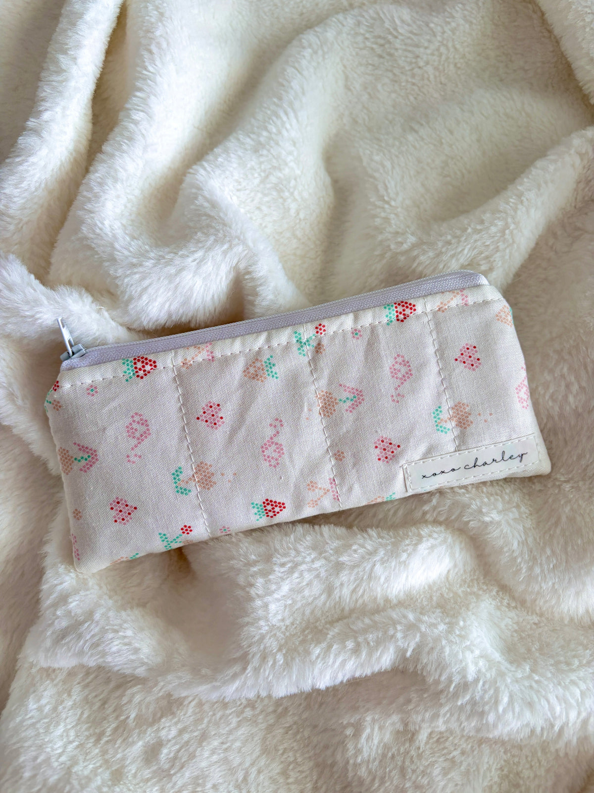 Pencil and glasses case with light gray fabric, colorful picnic icons, and zipper top