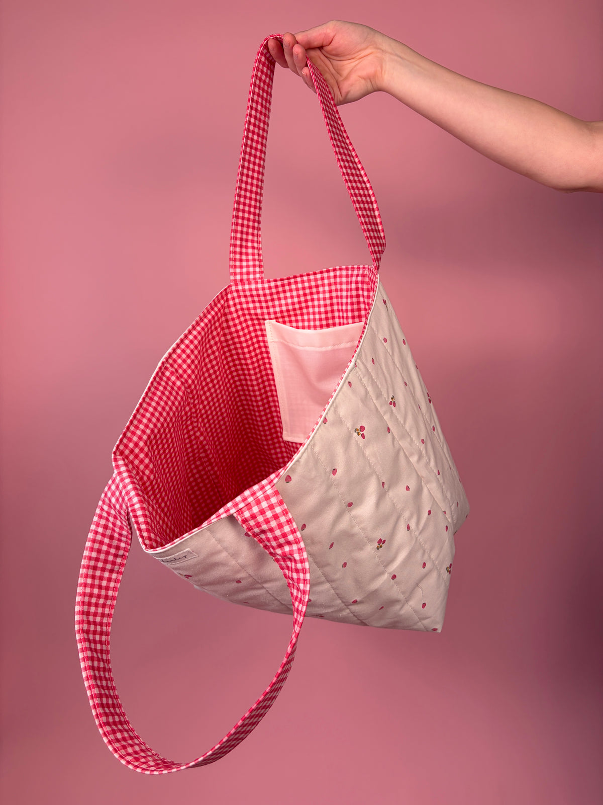 Large tote bag with red gingham exterior and white berry flower inner lining pocket