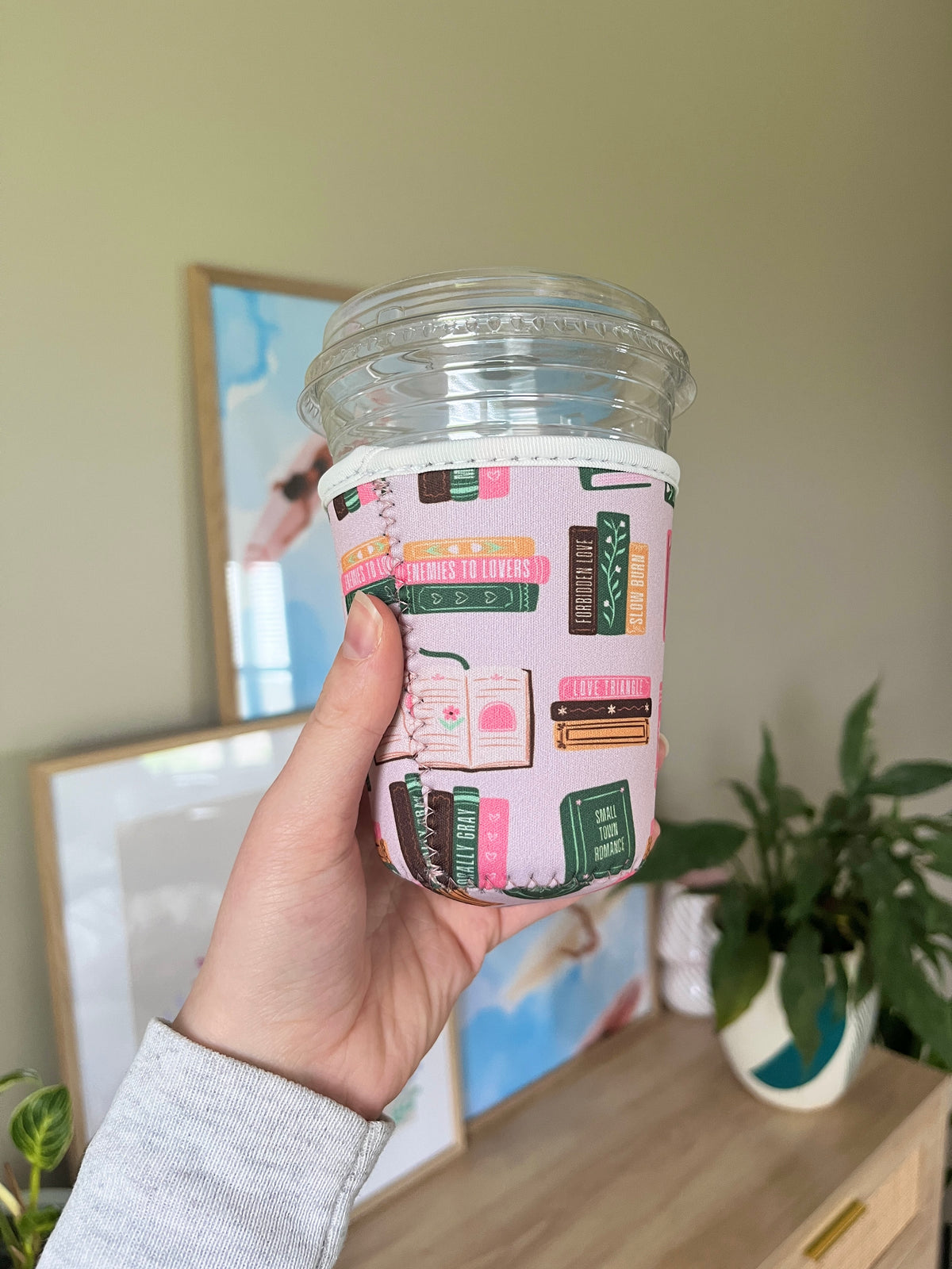 Printed cup sleeve on clear plastic cup with colorful book and text blocks