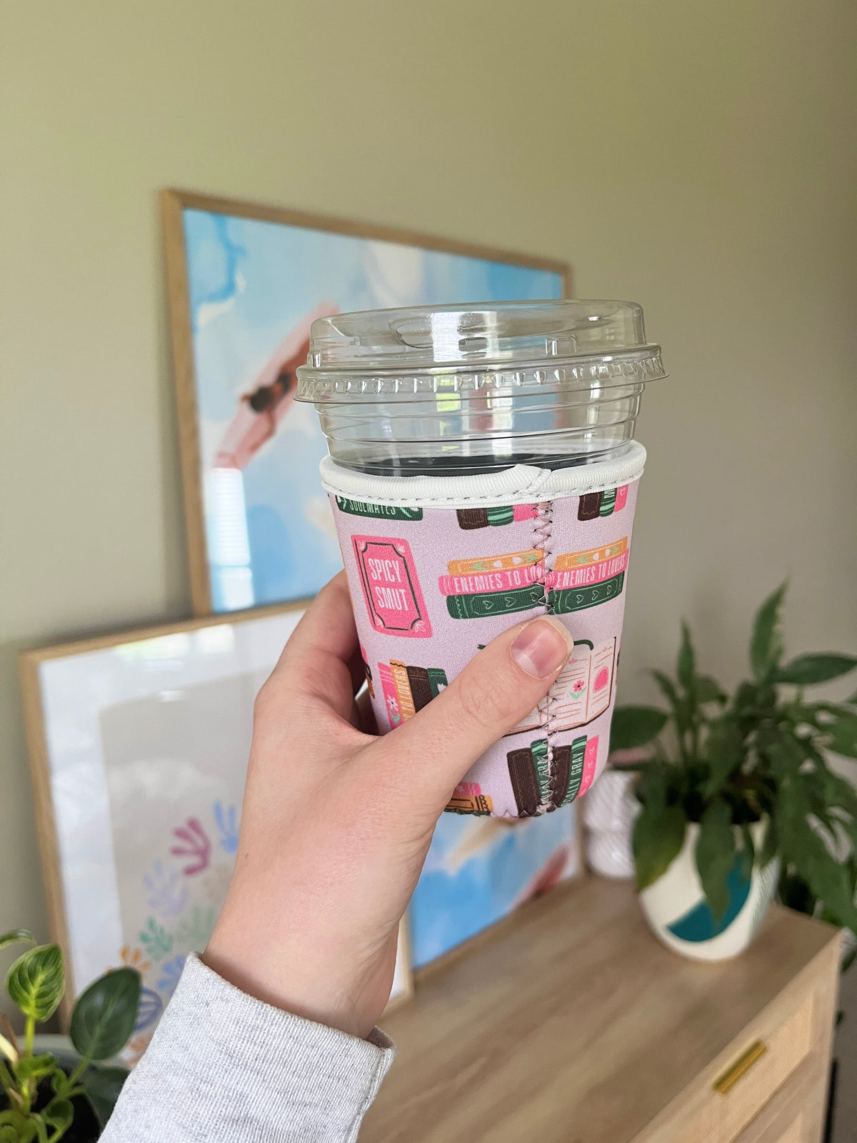 Printed cup sleeve on clear cup, multicolor rectangular text and book icons