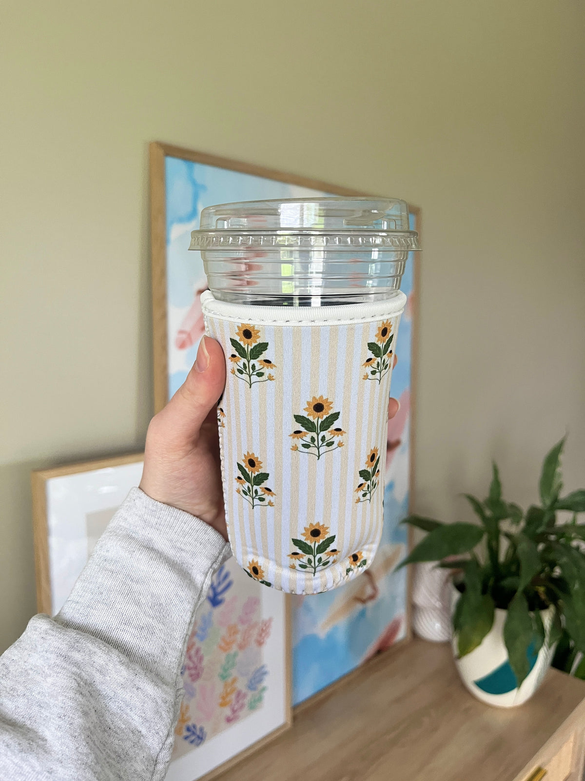 Sunflower cup sleeve with vertical stripes, floral prints, and visible lid