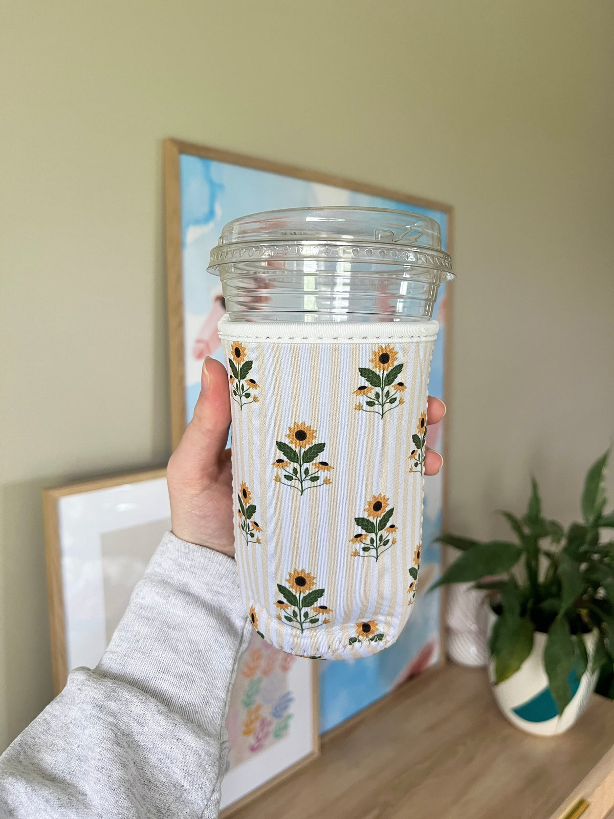 Sunflower cup sleeve with vertical stripes and floral motifs on clear cup