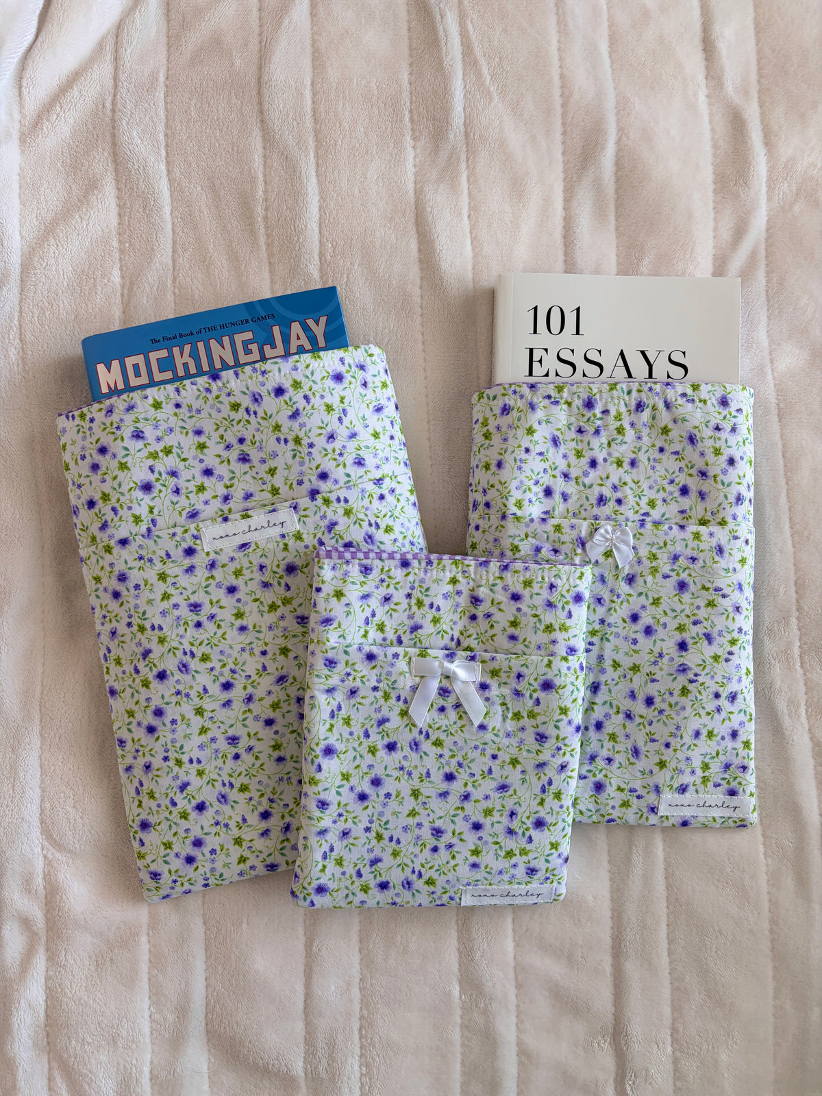 Purple floral e-reader/book sleeve with three book-sized pockets holding covers