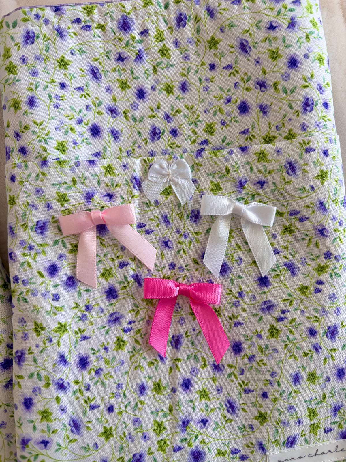 Purple floral e-reader/book sleeve with layered white, pink, and magenta bows