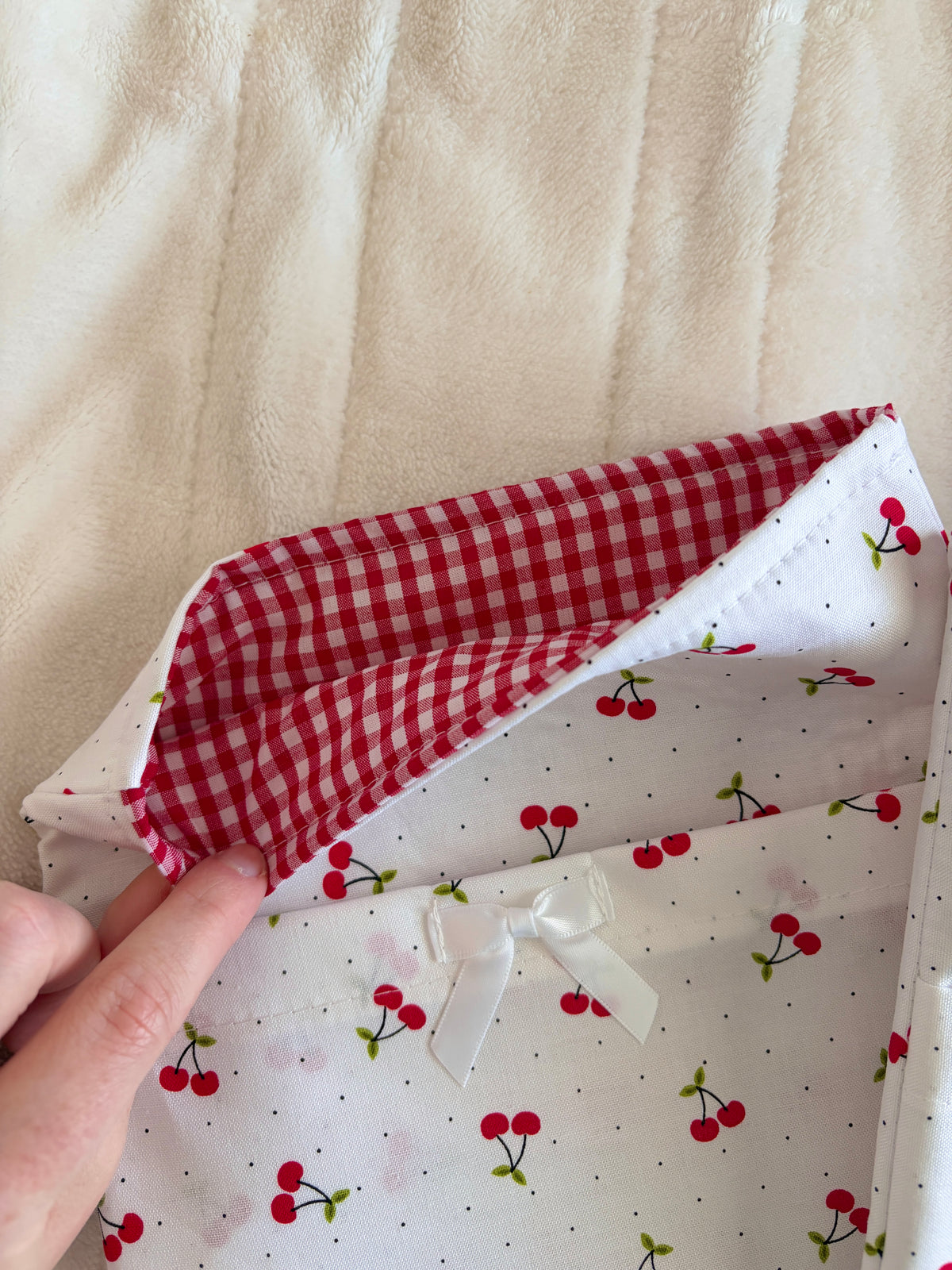 Cherry-print e-reader/book sleeve with red check lining and folded opening