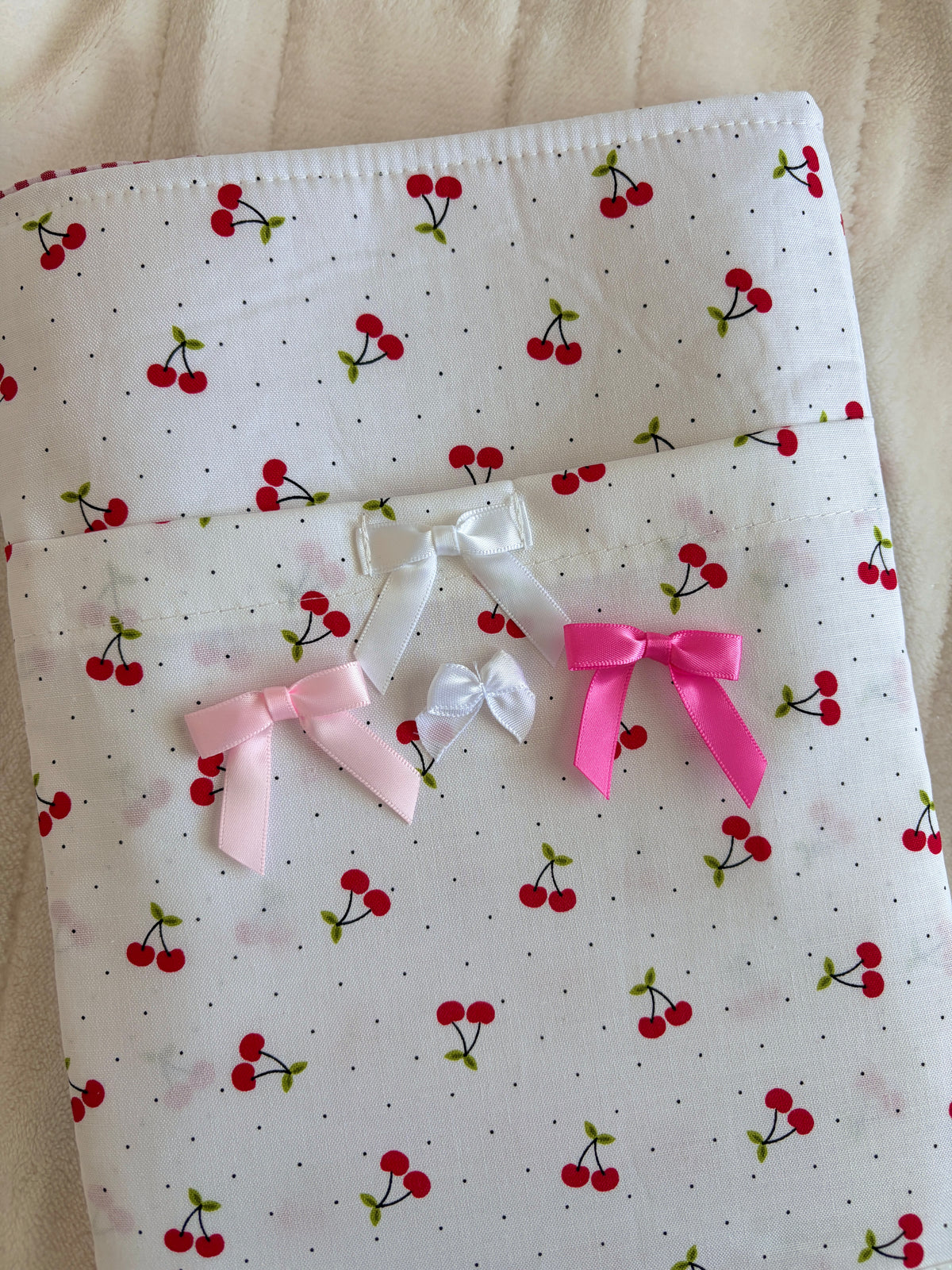 Cherry-print e-reader/book sleeve with large pink and white bows on front