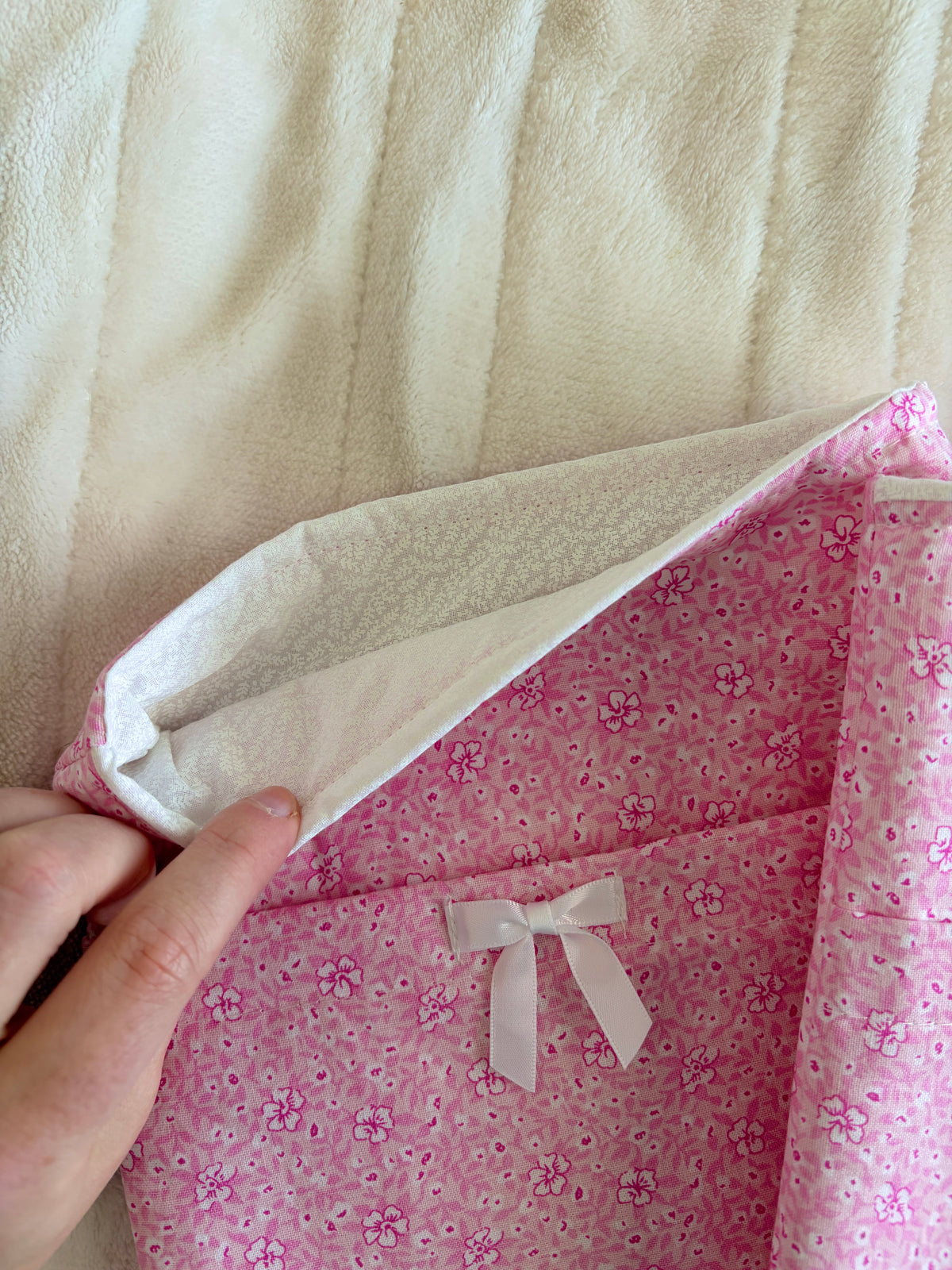Pink floral e-reader sleeve with white ribbon bow, open top showing inner lining