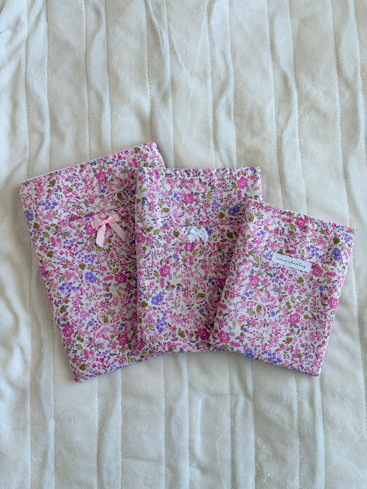 Pink floral e-reader book sleeves with ribbon bows, folded set of three