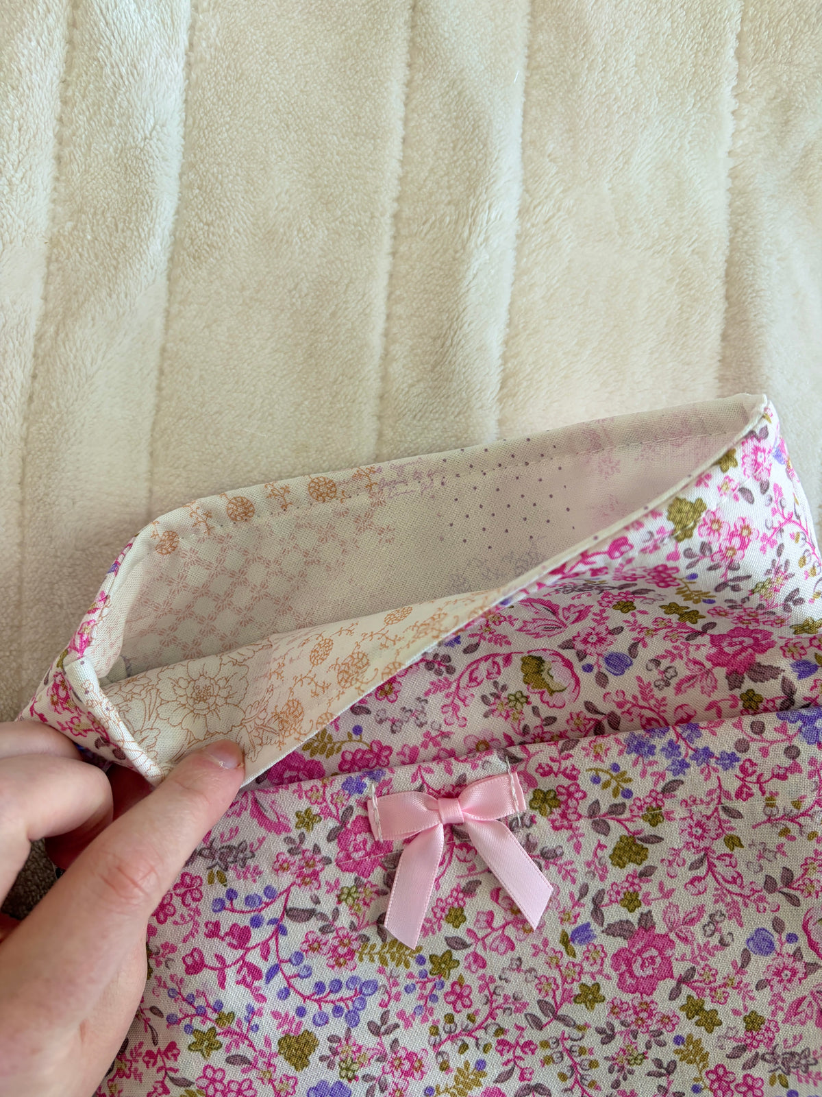 Pink floral book sleeve with bow, showing beige interior lining