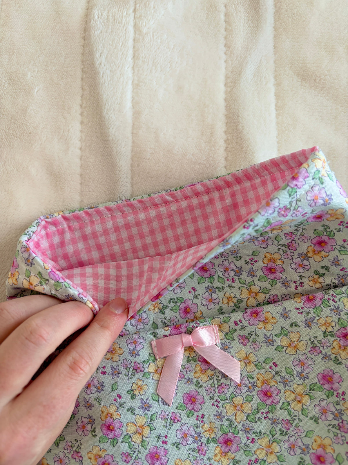 Floral e-reader/book sleeve with pink gingham lining and ribbon bows, close-up