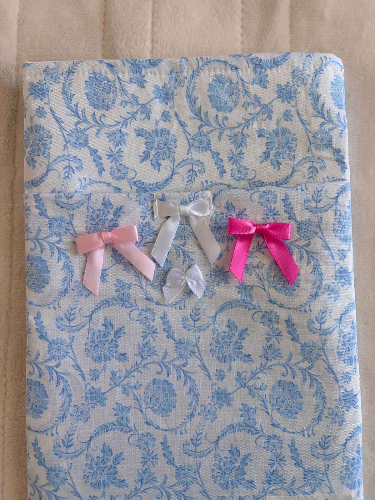 Blue floral e-reader sleeve with ribbon bows in white, pink, and magenta