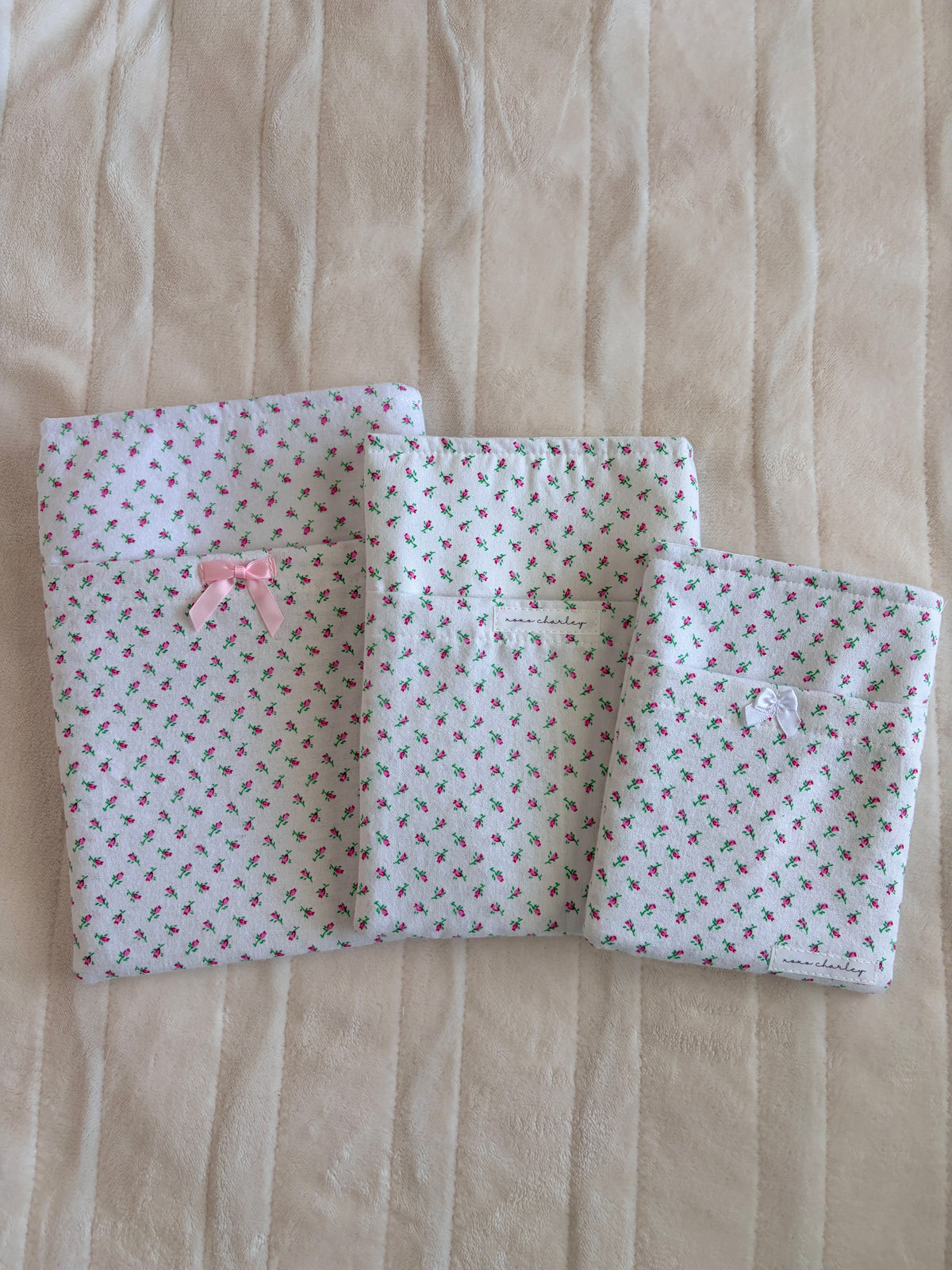 Mini rose print e-reader/book sleeve, open with pink bow center, flap style.