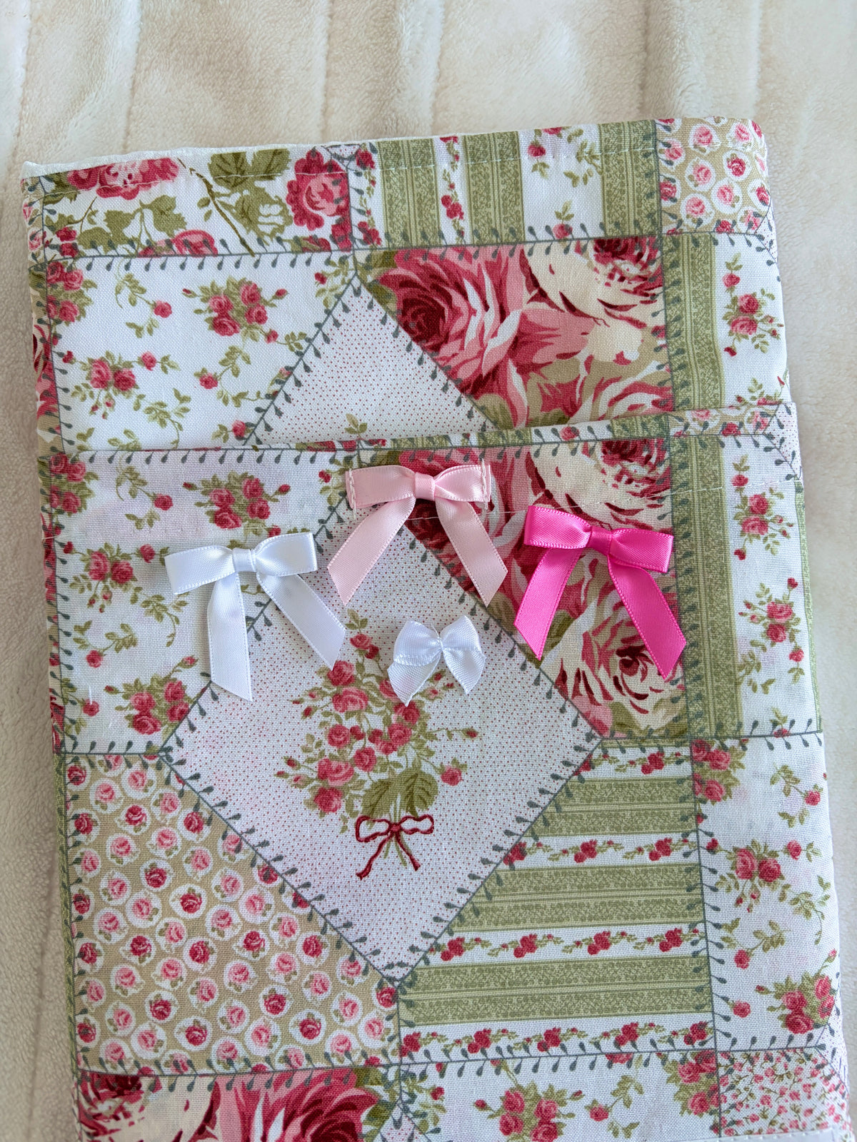 Floral patchwork e-reader sleeve with pink and white tied rosette decorations