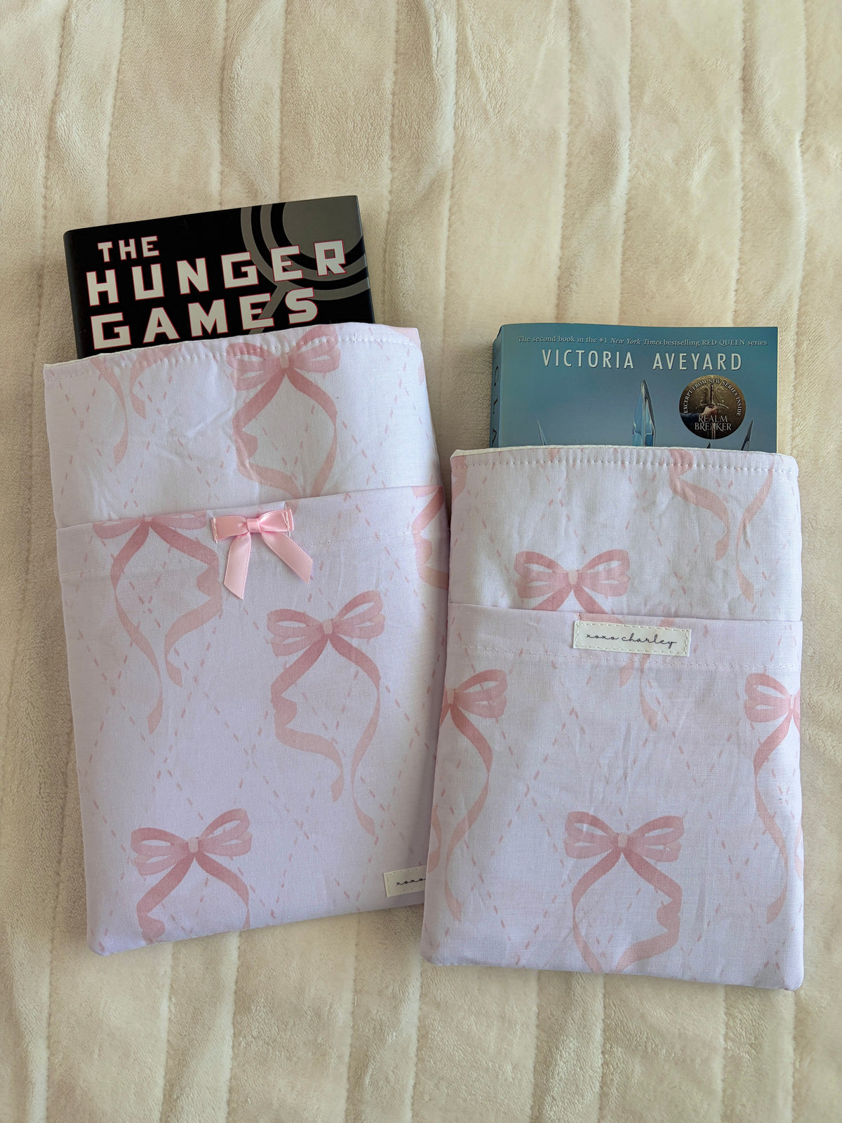 Light pink bow-pattern e-reader/book sleeve with front tab and ribbon bow
