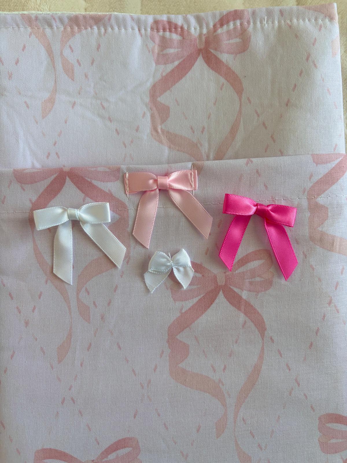 Light pink e-reader/book sleeve front with large ribbon bows in pink tones