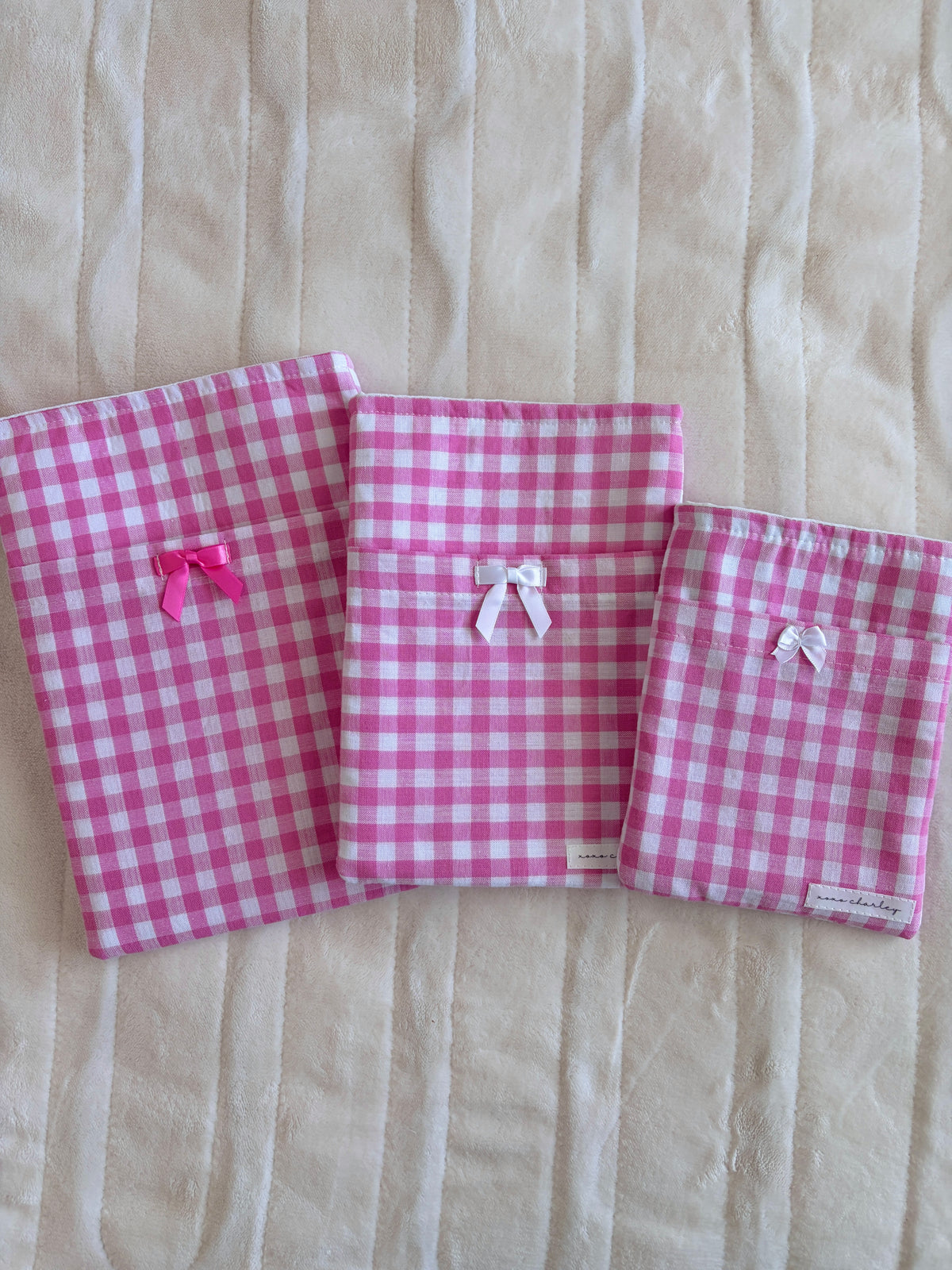 Pink gingham e-reader and book sleeves, each with small white bow