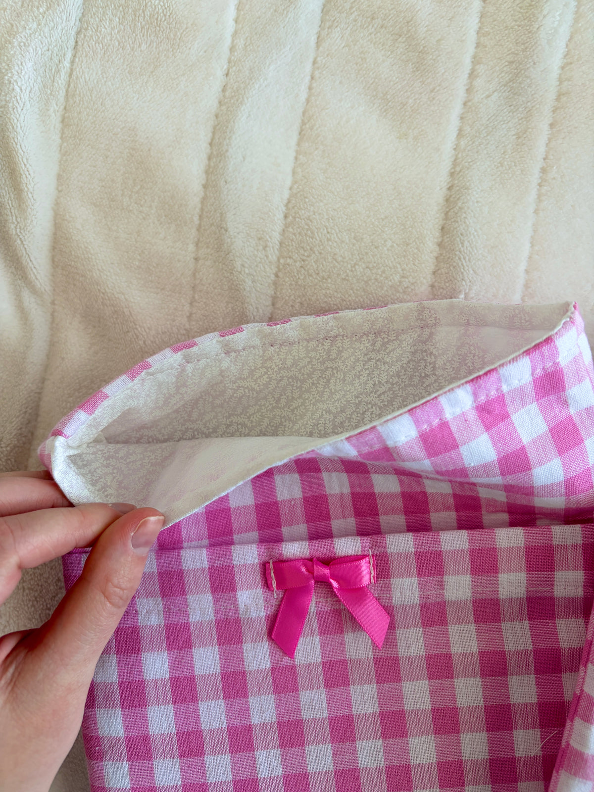 Pink gingham e-reader sleeve with pink ribbon bow and stitched edge