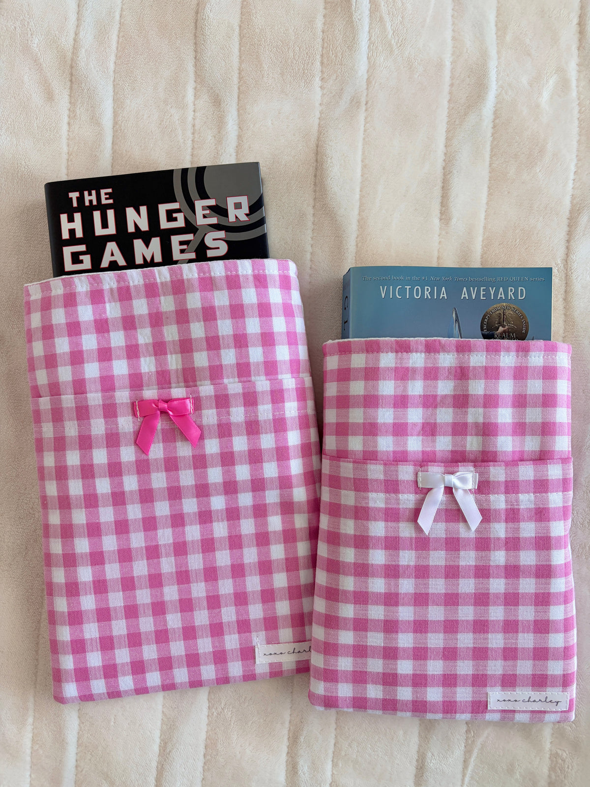 Pink gingham e-reader and book sleeve set with white bows, front view