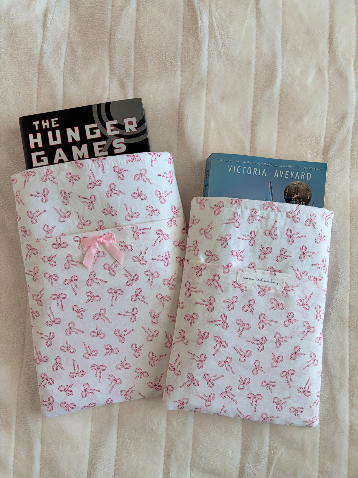 Mini e-reader/book sleeve with pink bow pattern and light pink ribbon bow on flap