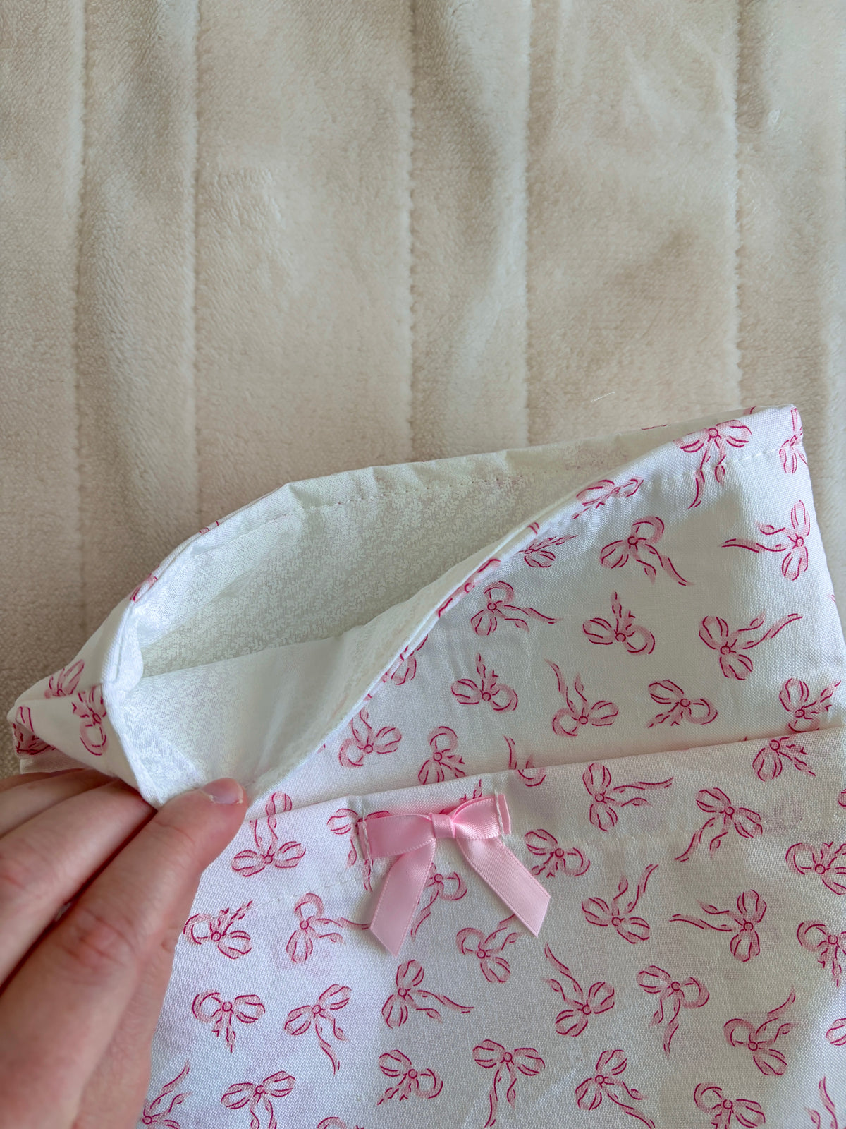 Mini e-reader/book sleeve fabric close-up with light pink bow print and inner lining