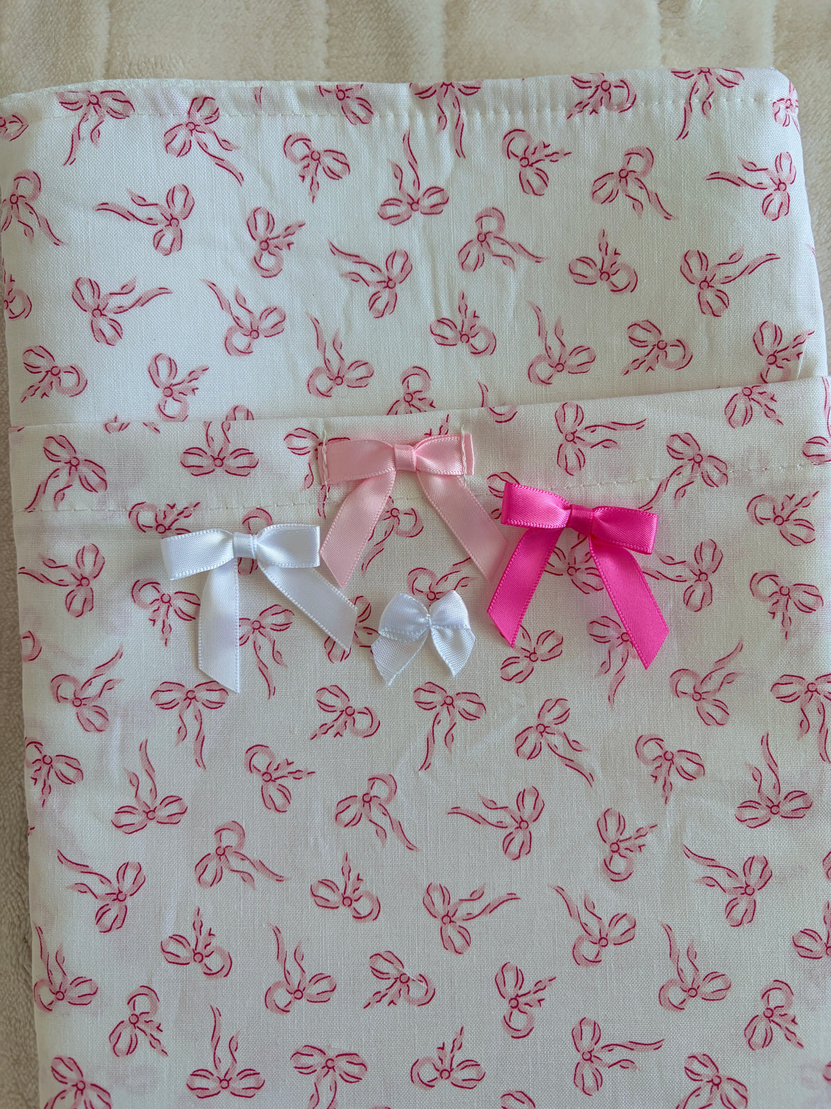 Mini e-reader/book sleeve with pink bow pattern and white plus pink ribbon bows