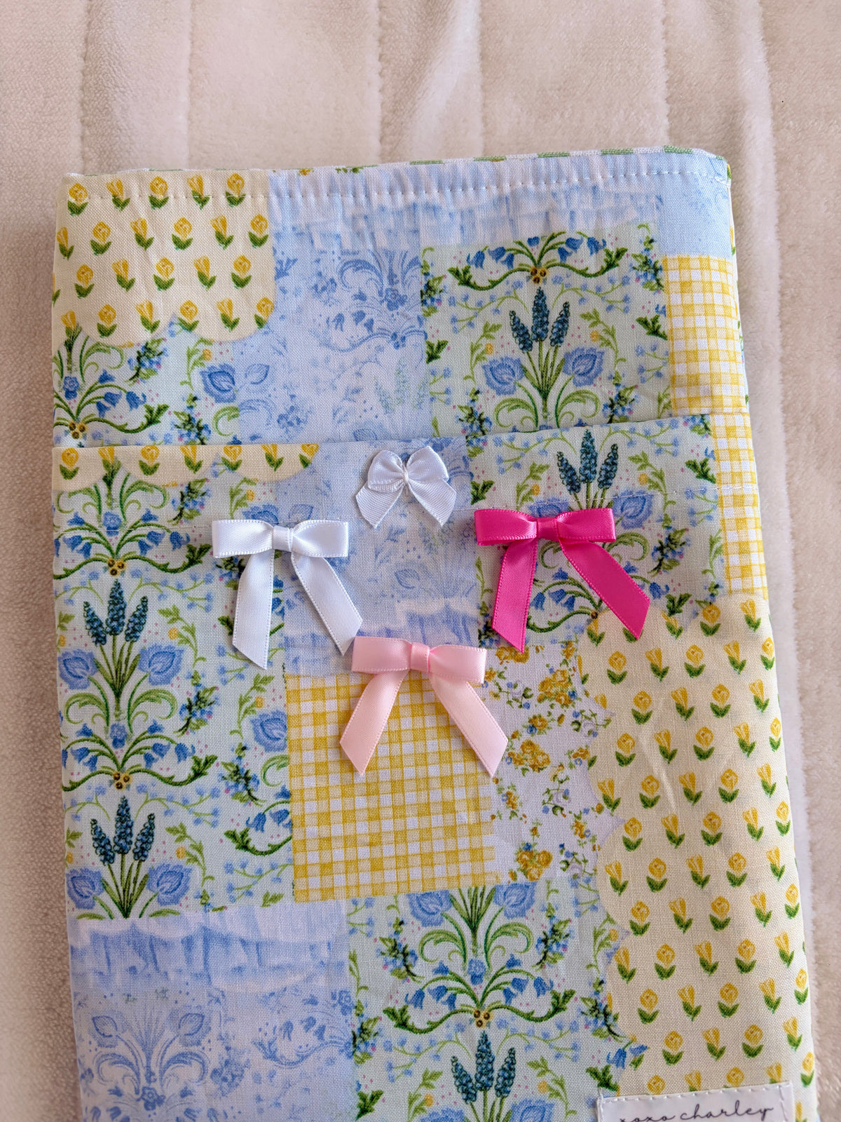 Patchwork e-reader/book sleeve with layered bows in white, pink, and magenta
