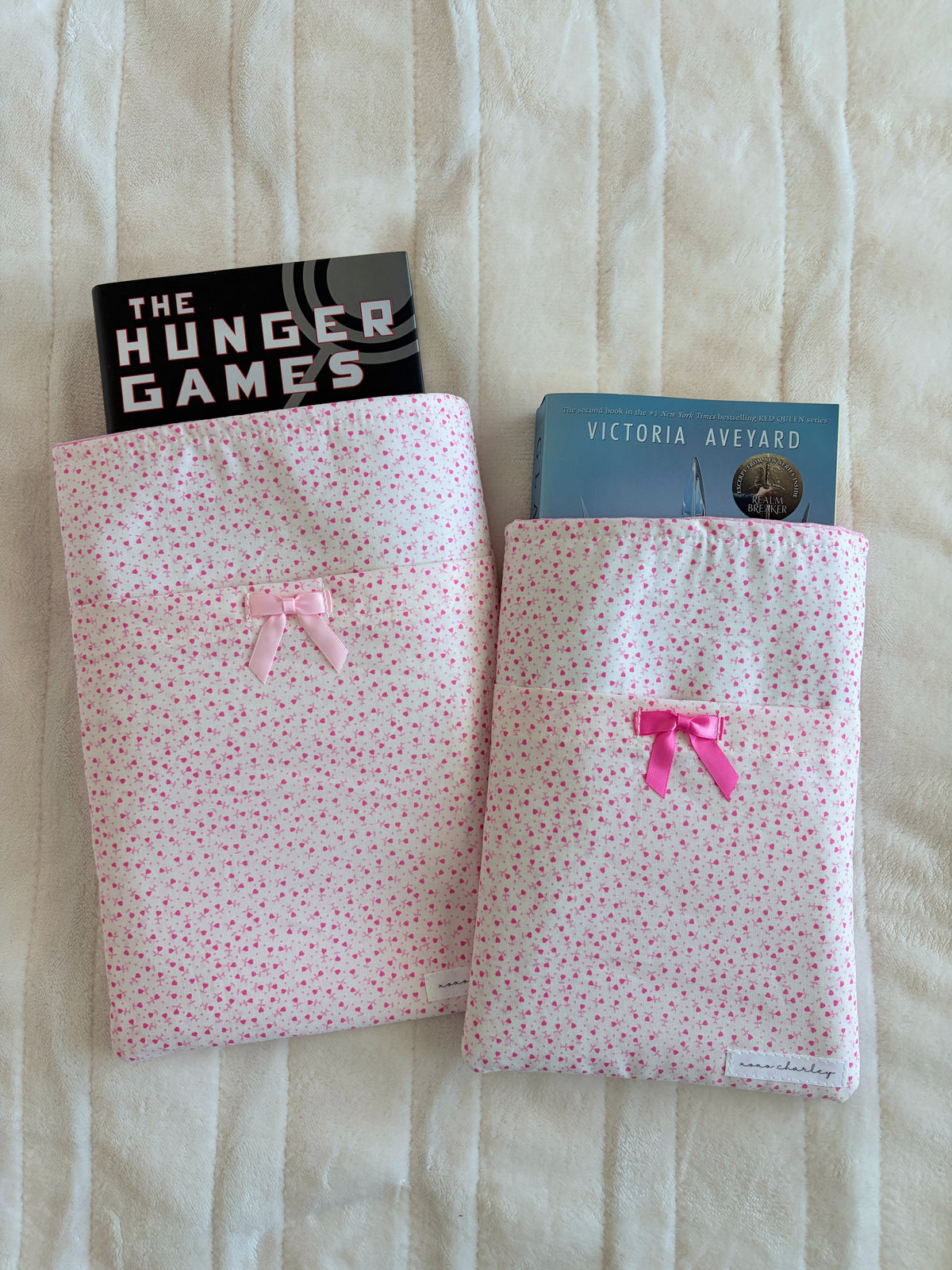 Set of two pink tiny-heart book sleeves with satin bows, front view