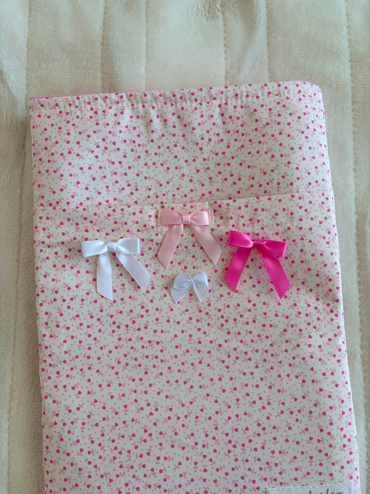 Pink tiny-heart book sleeve front with three satin bows in white and pink tones