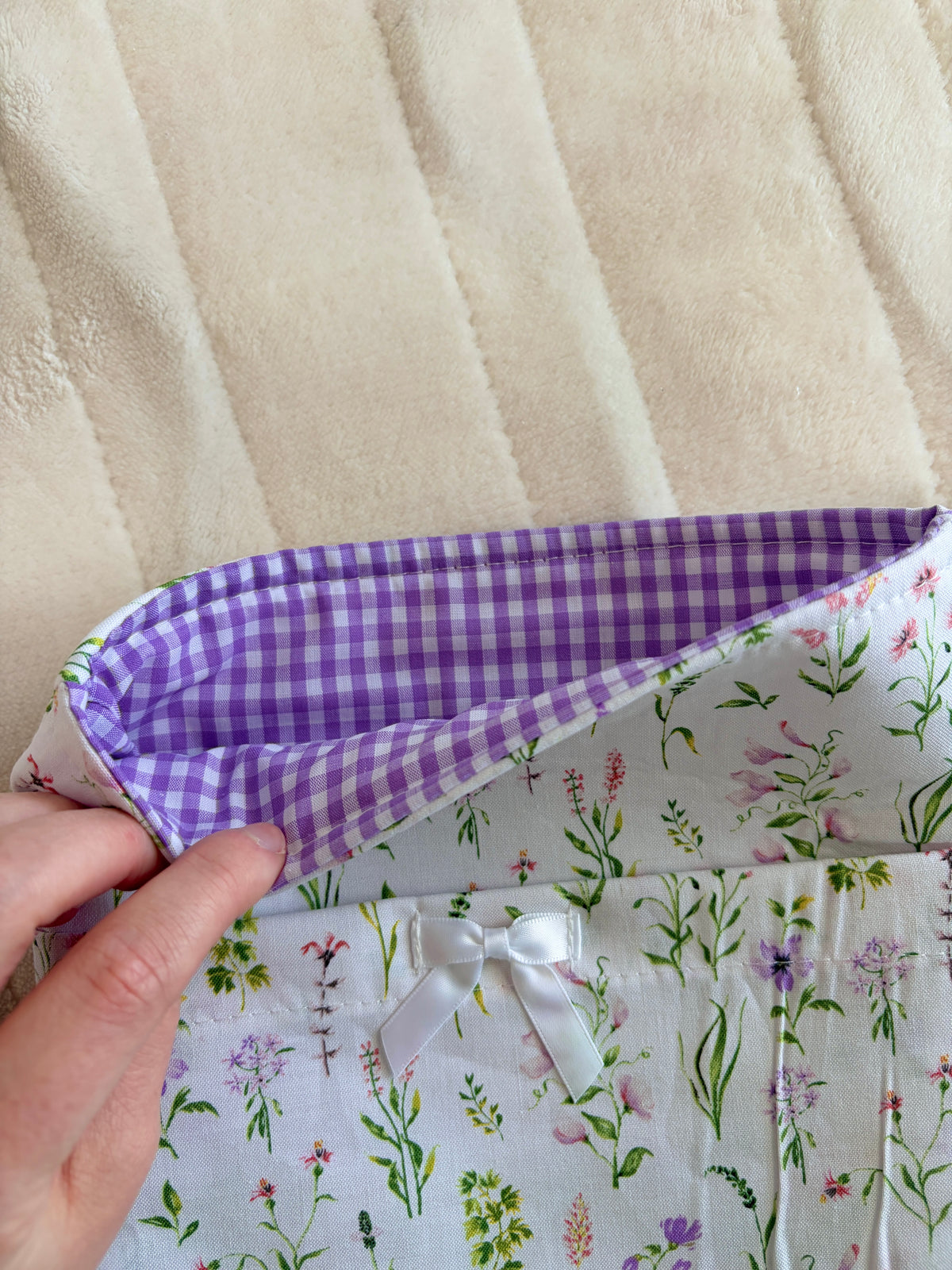 Wildflower book sleeve with purple gingham interior, hands holding the open top