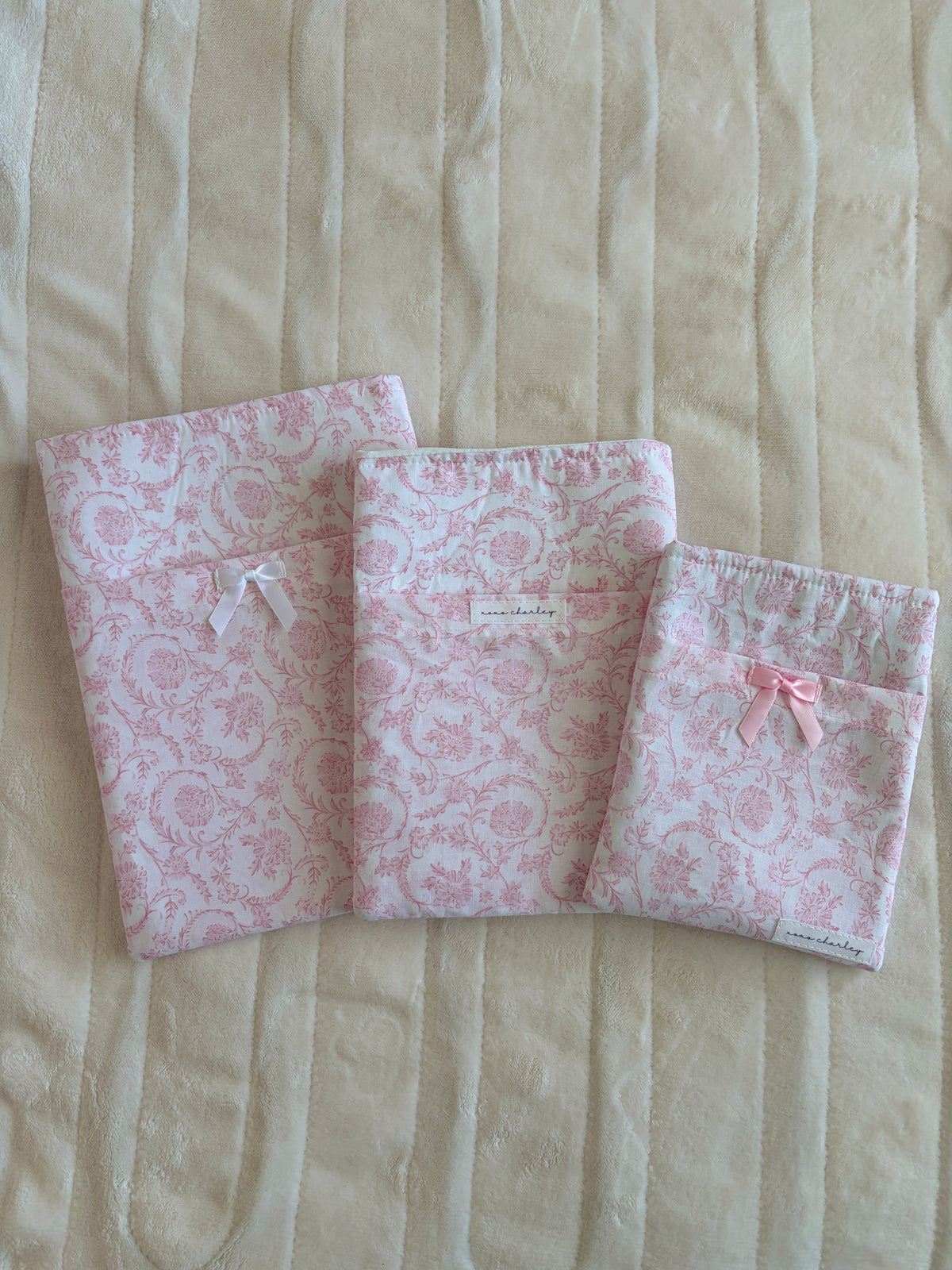 Pink vintage e-reader/book sleeve with white ribbon bows, open tri-fold view.