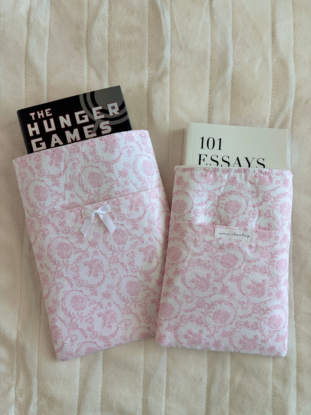 Pink floral e-reader/book sleeve with white ribbon bows and inner name label pocket.