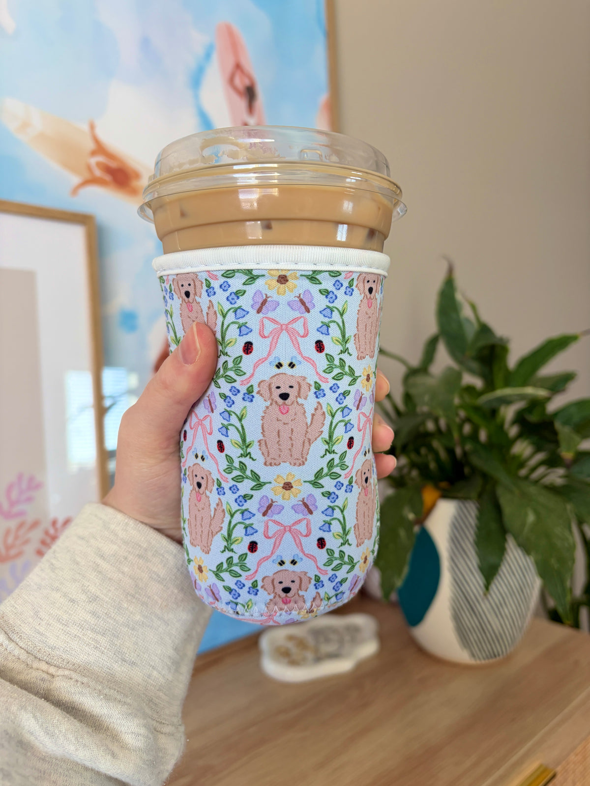 Medium pup cup sleeve with colorful dog and flower pattern, fabric wrap around cup
