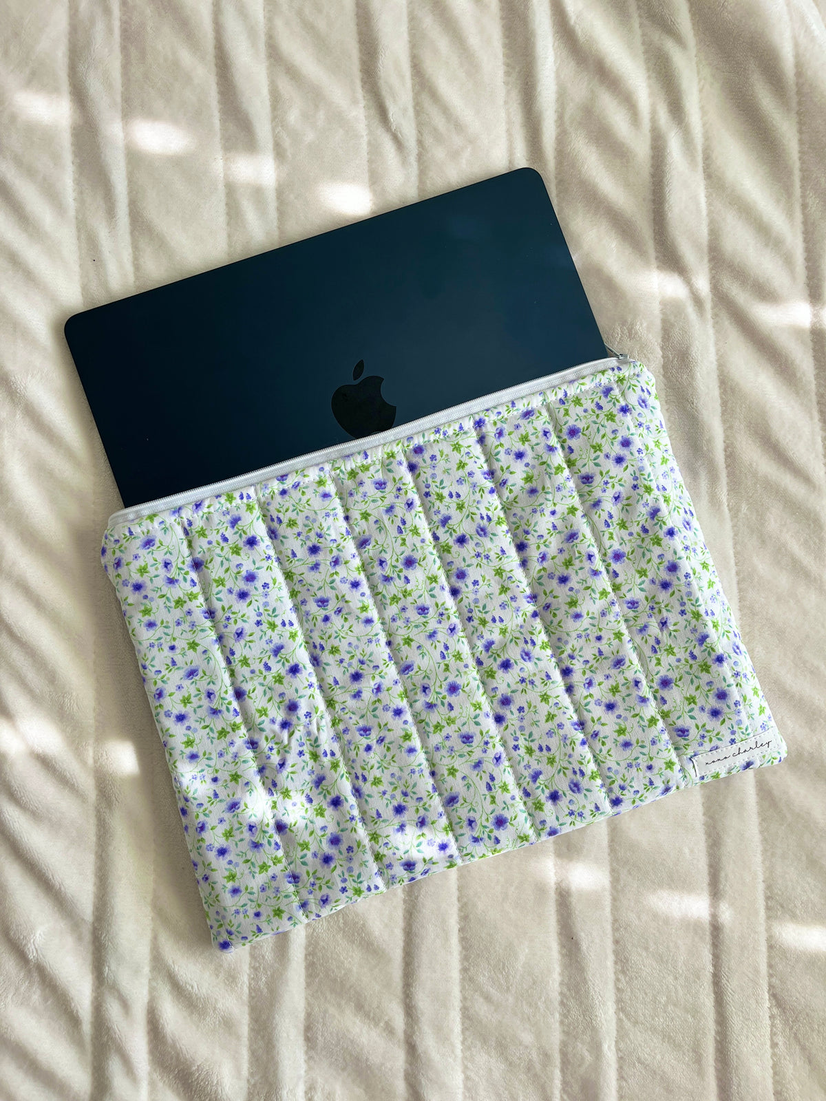 Floral laptop & tablet sleeve with zipper, holding a dark tablet