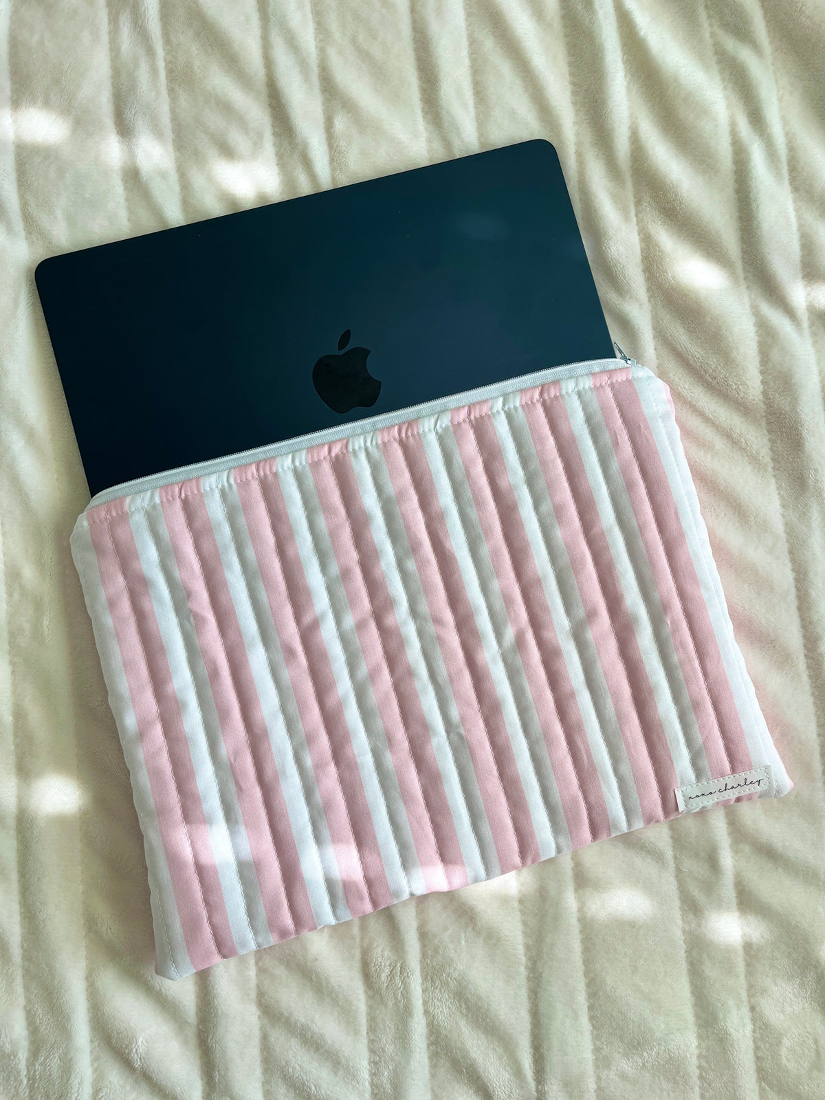 Pink and white striped laptop and tablet sleeve holding a device