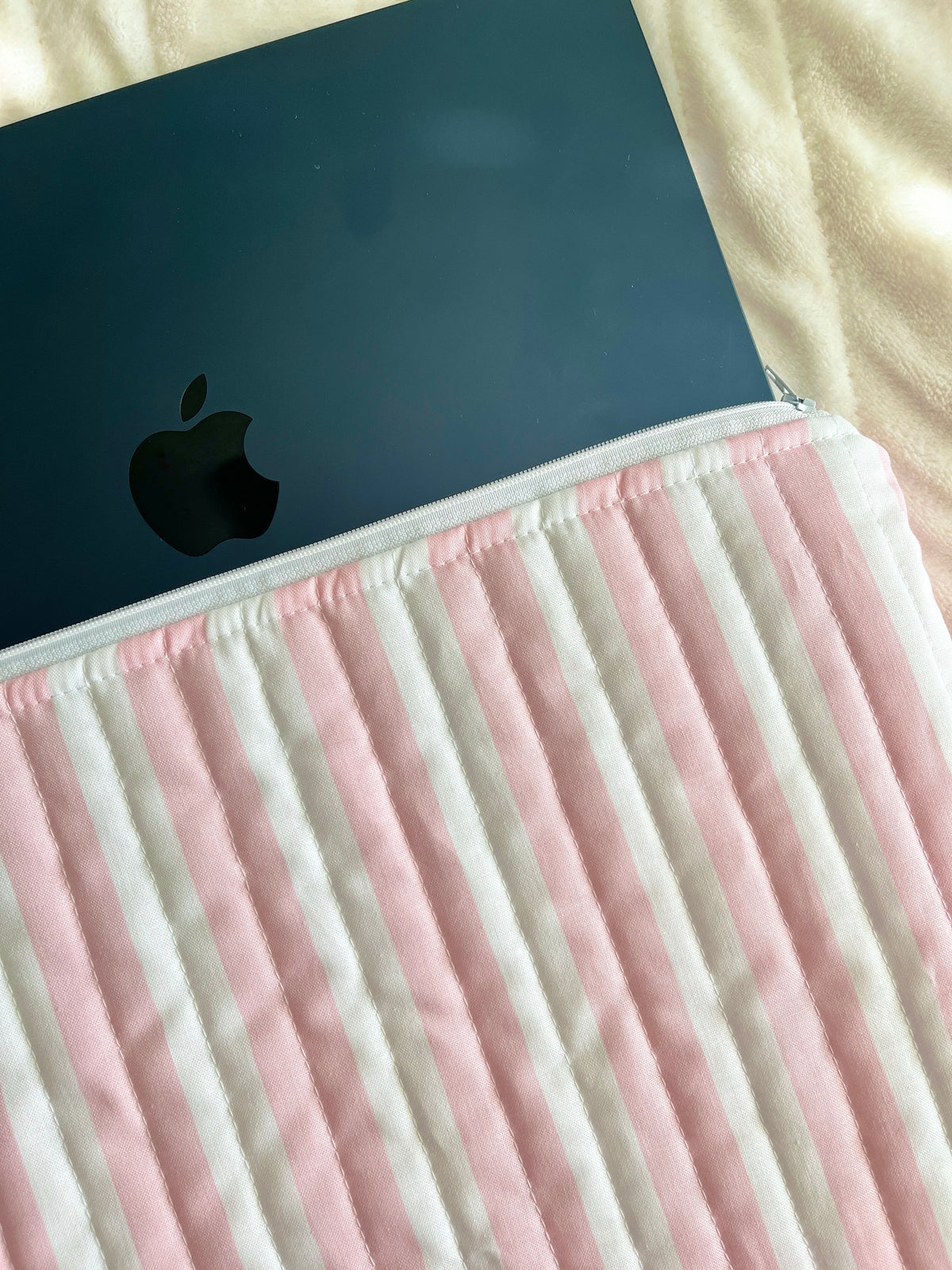 Pink and white striped laptop and tablet sleeve with device edge visible
