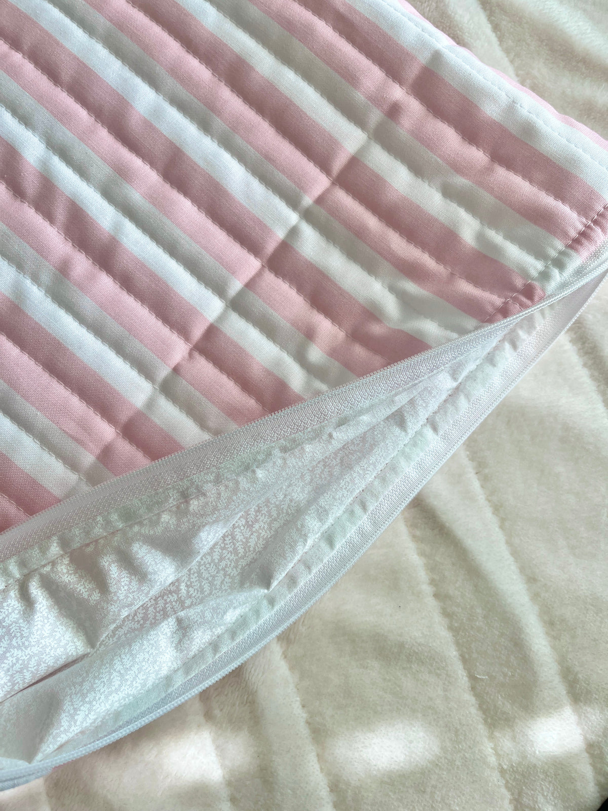Pink and white striped sleeve with white trim along the edge