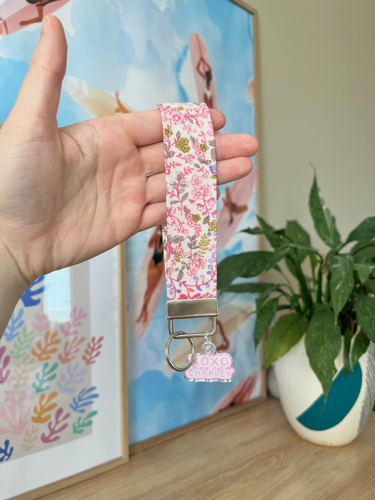 Floral wristlet keychain with metal lobster clips and pink patterned strap