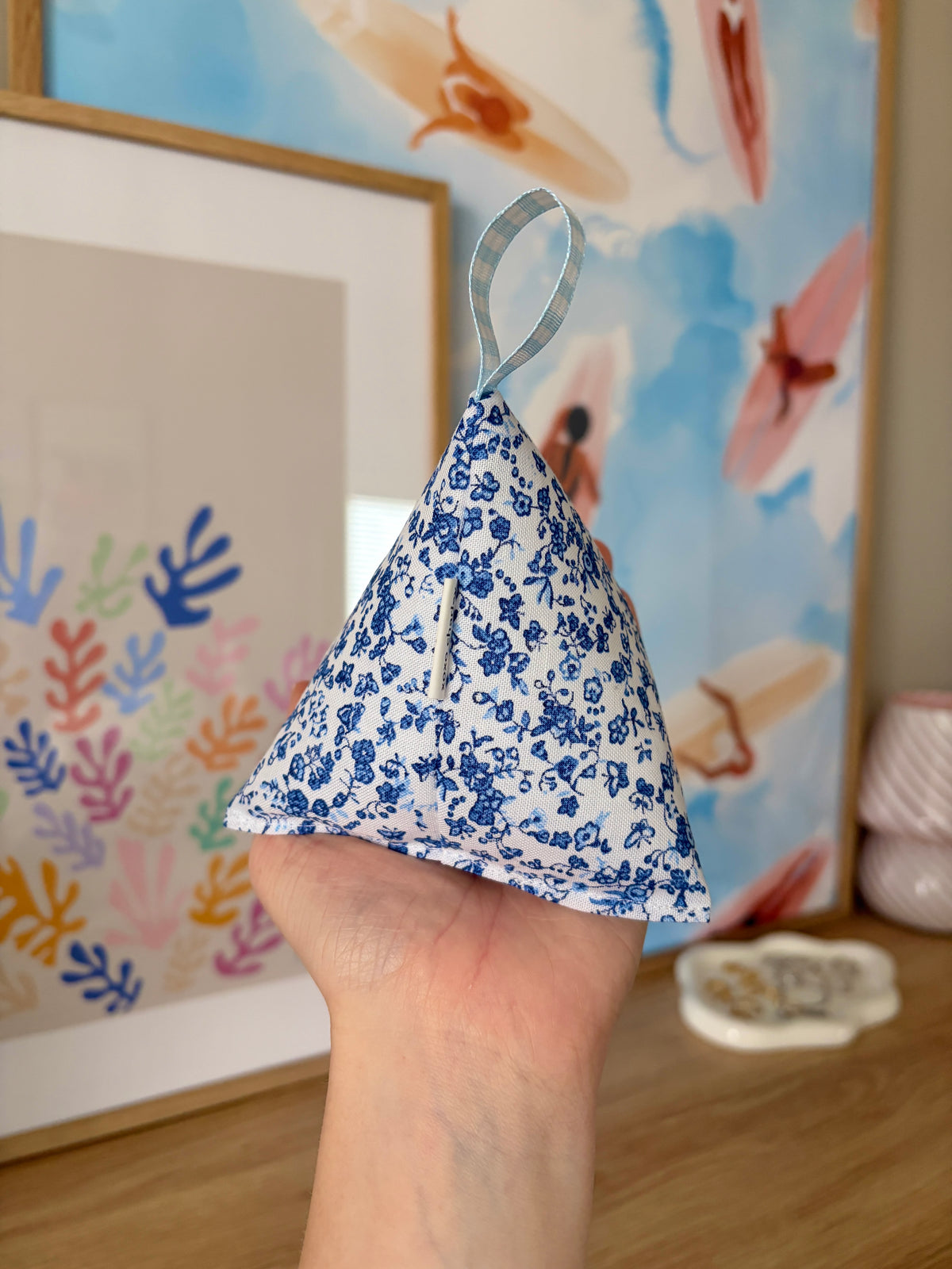 Blue floral triangular fabric weight with looped blue check ribbon