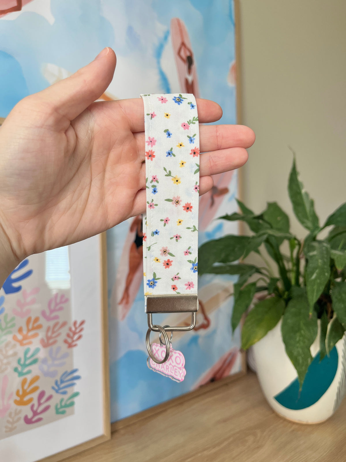 Mini floral keychain wristlet with white strap and colorful flower print, silver clip