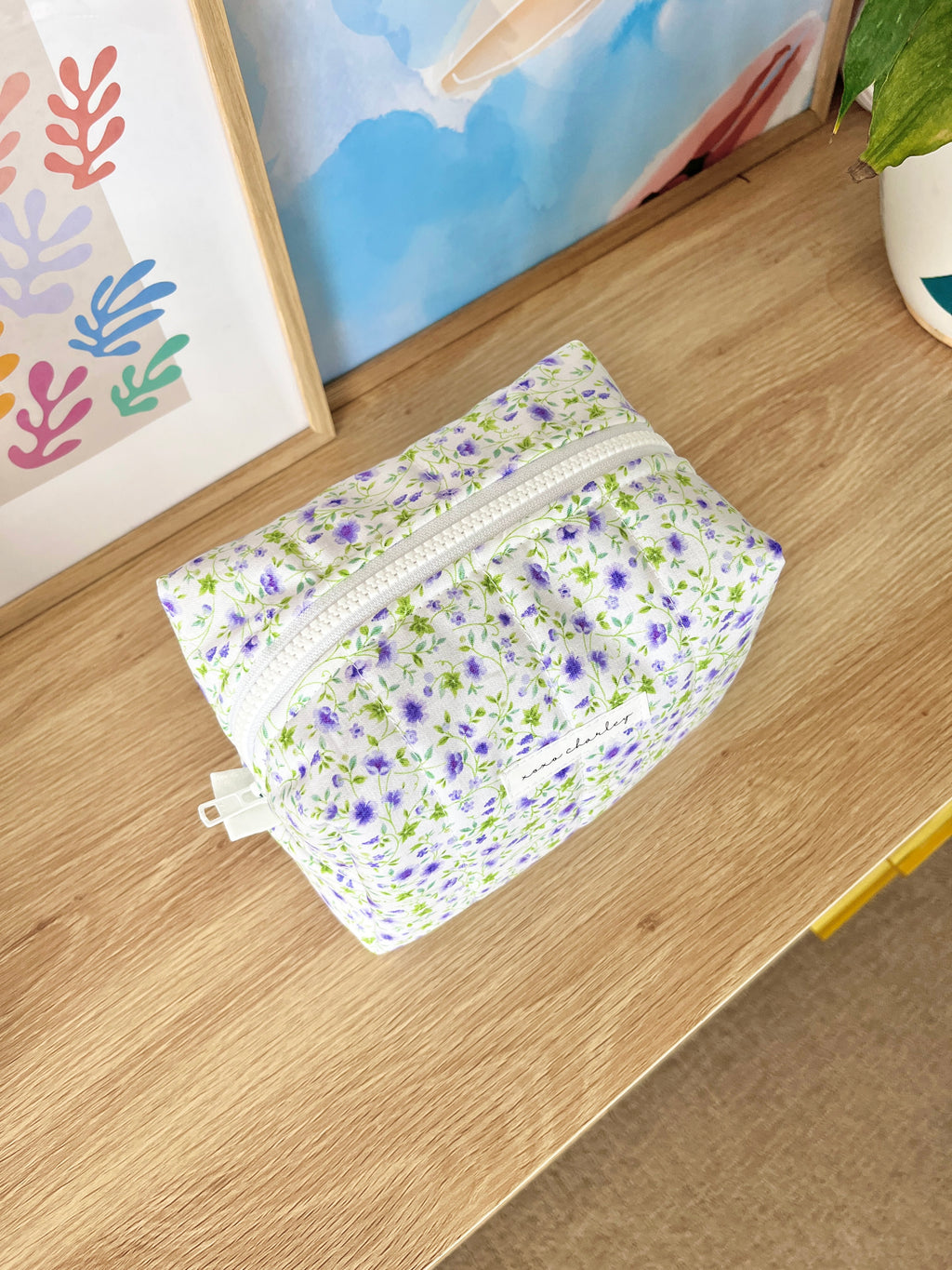 Medium floral makeup bag, purple and white print, front zipper panel
