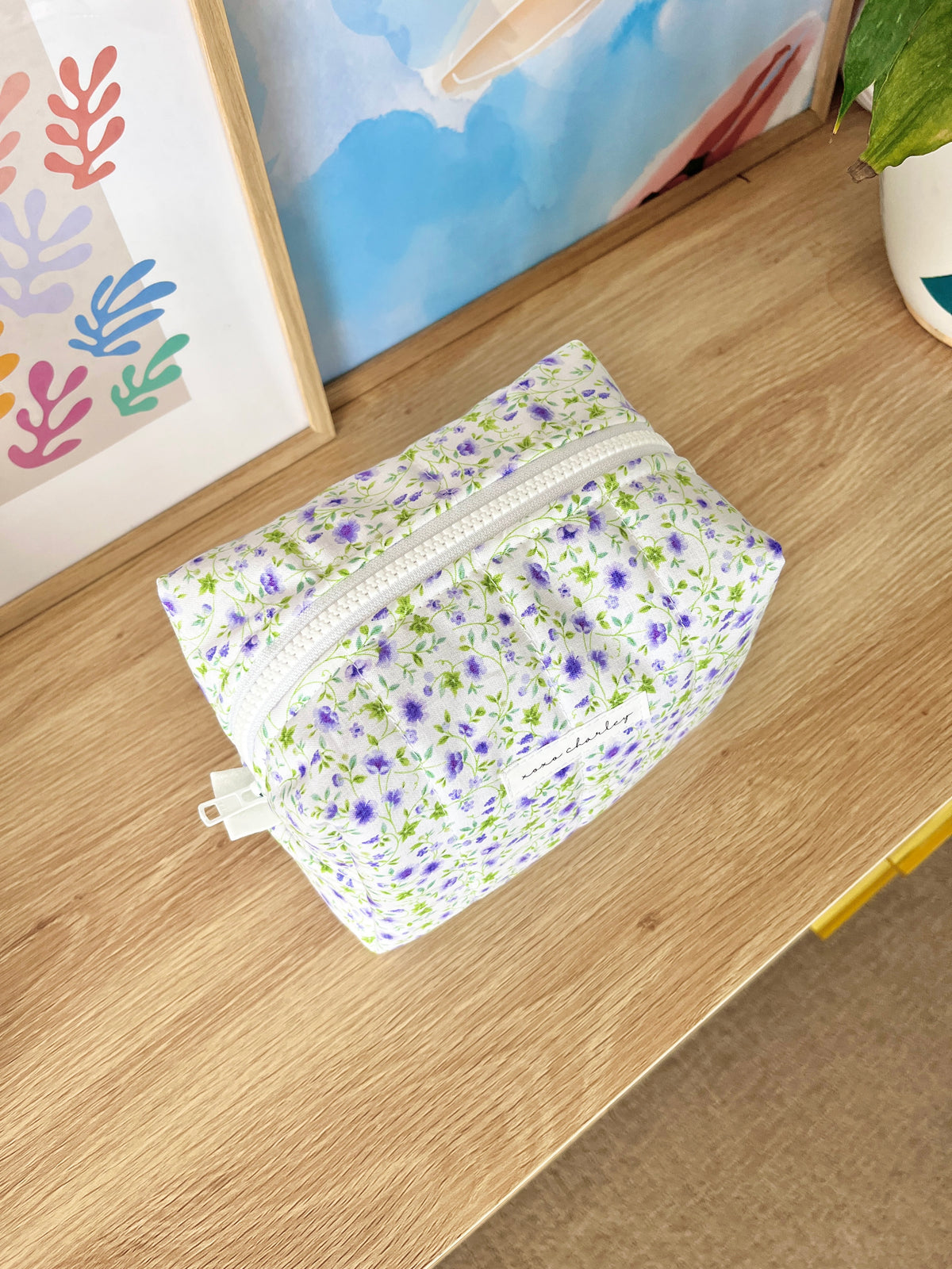 Medium floral makeup bag, purple and white print, front zipper panel