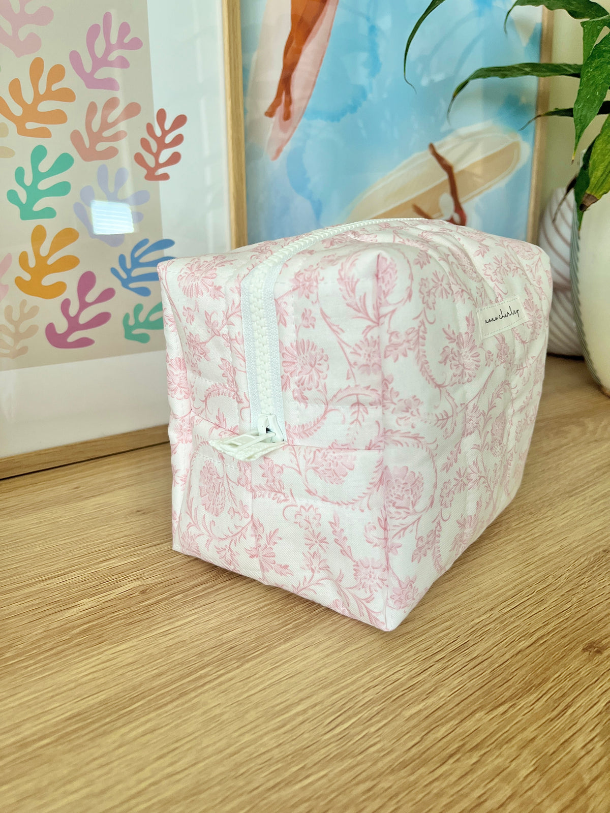 Pink floral medium makeup bag, back view with top handle and zipper
