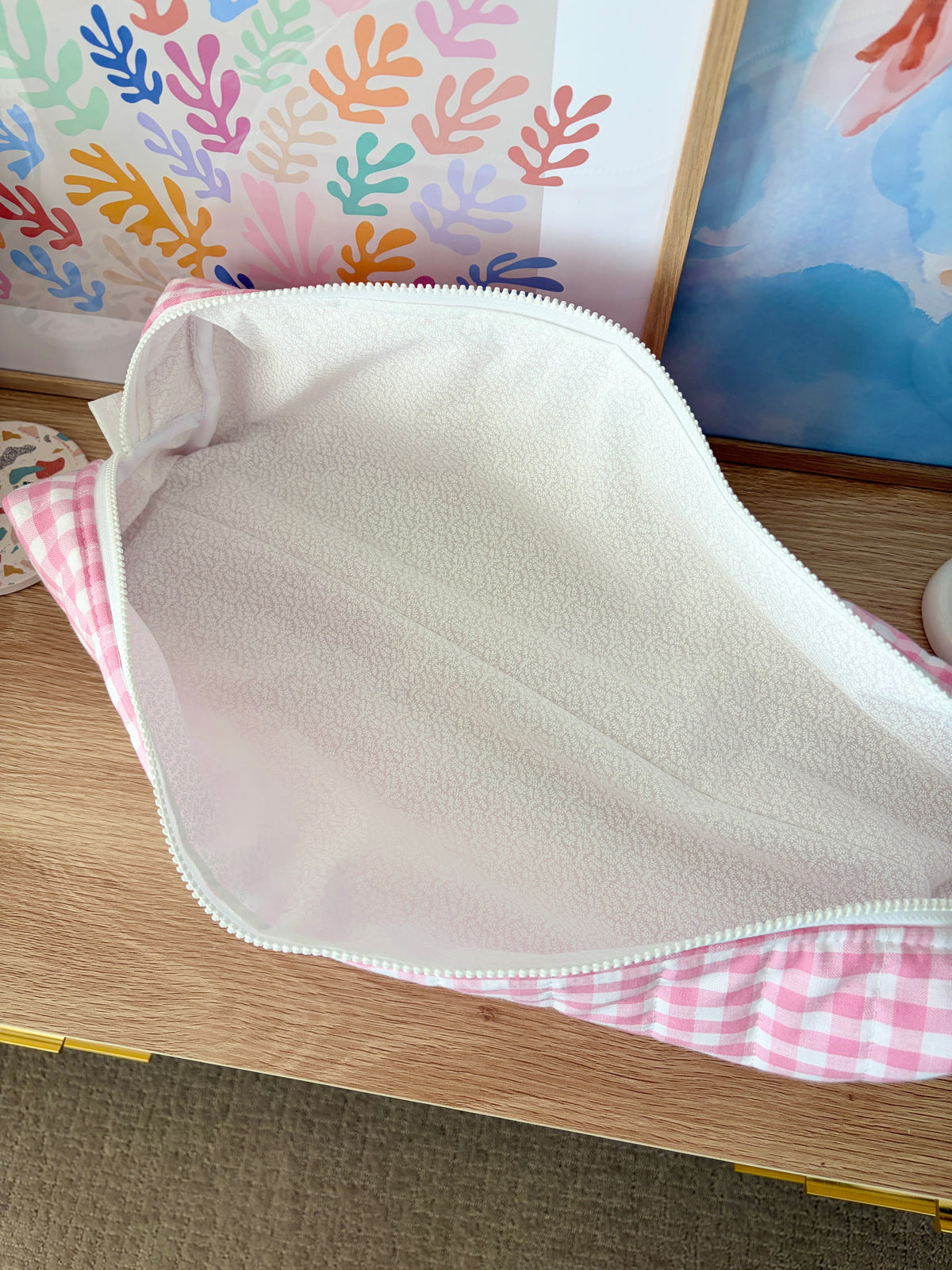 Open pink gingham hair tools bag with white fleece interior and mint zipper trim