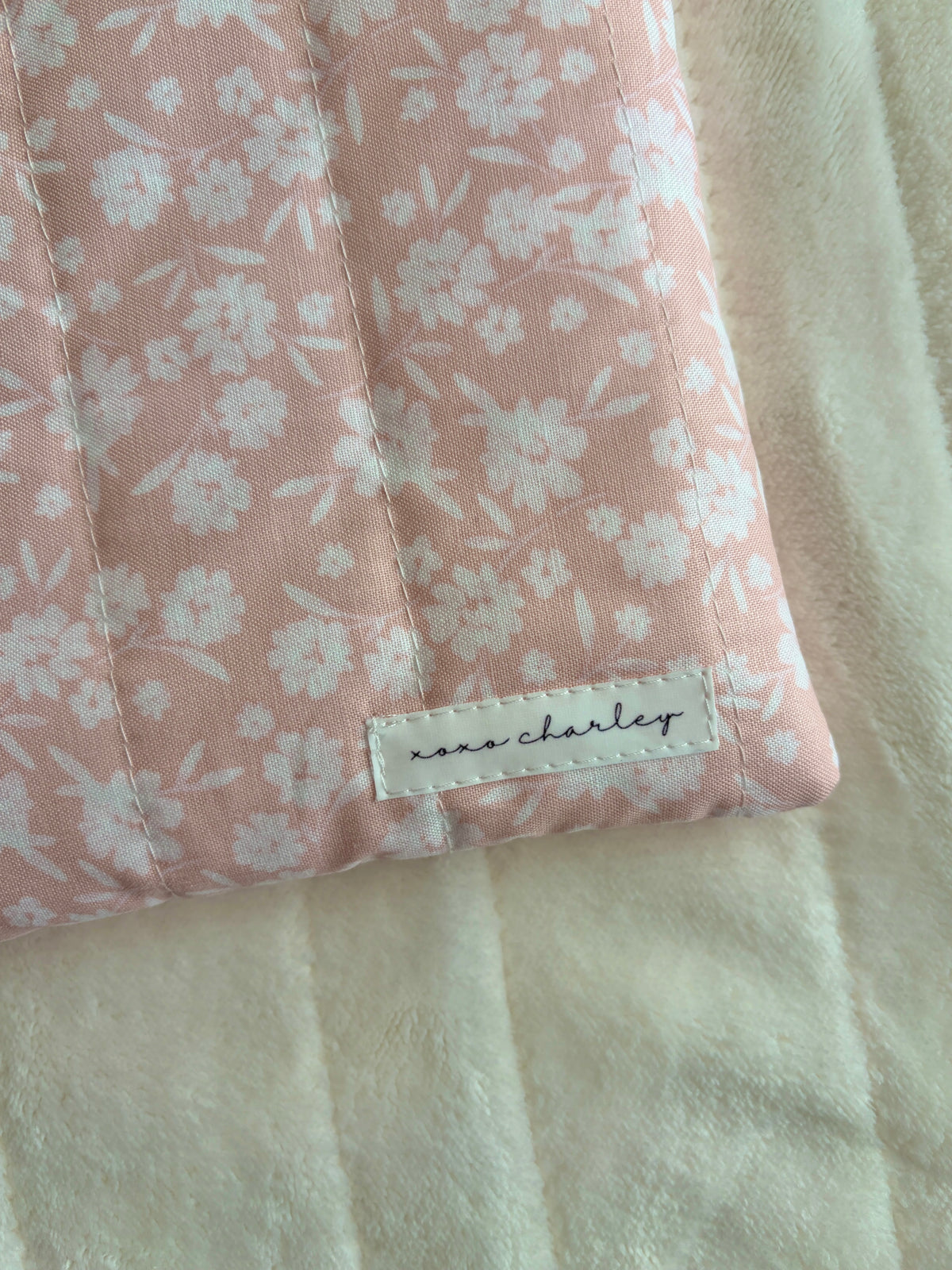 Blush pink floral sleeve with stitched brand label and light blue edge trim