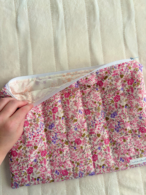 Pink floral laptop sleeve opened, showing light interior lining